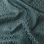 Teal-green satin folded over, the oval lattice texture reading cool against the muted green base