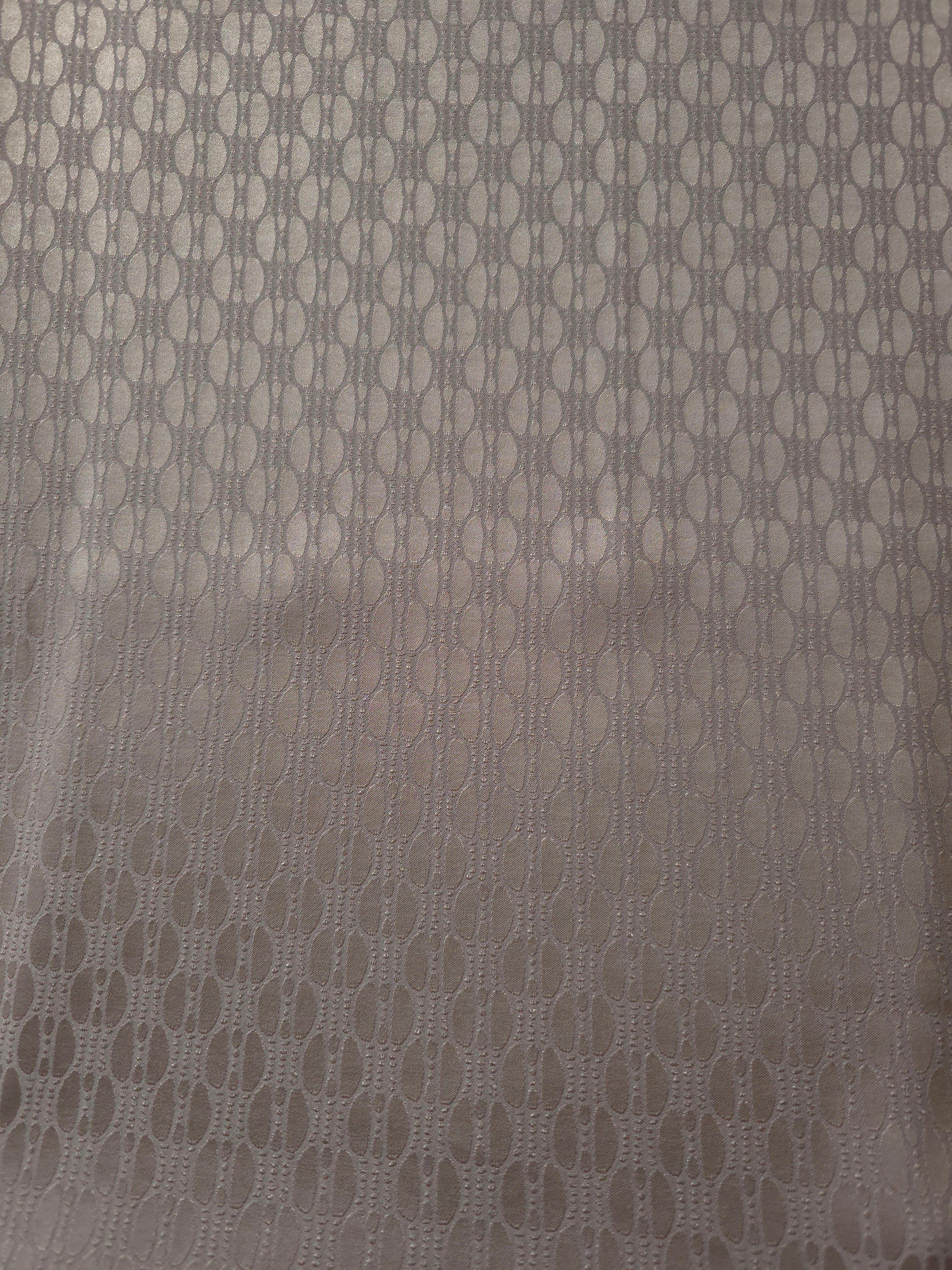 A wider view of the taupe-bronze oval lattice satin laid flat, showing the full repeat