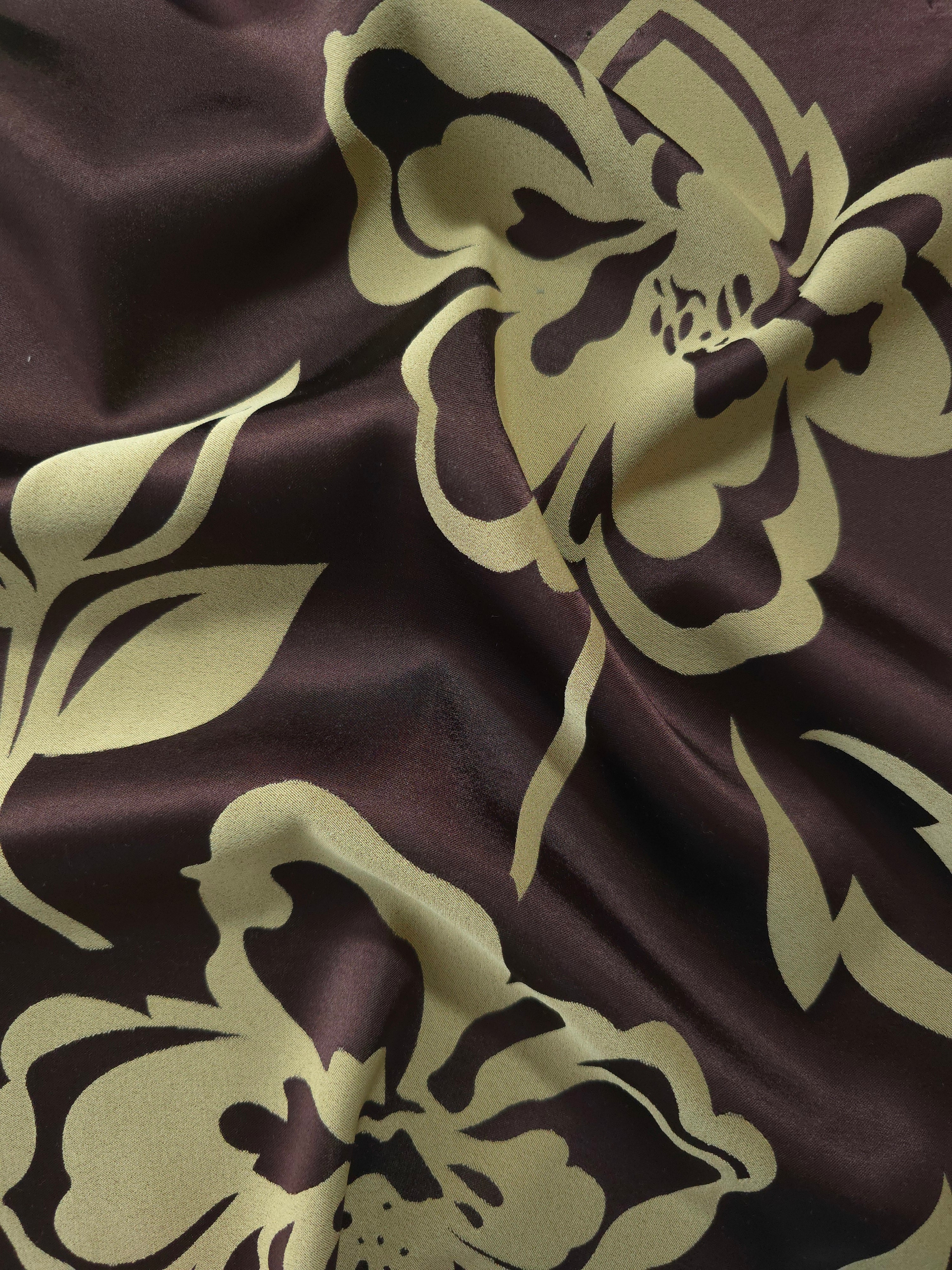 Aubergine satin folded over, the sage-green pansy flower silhouette standing out boldly against the deep purple-brown base