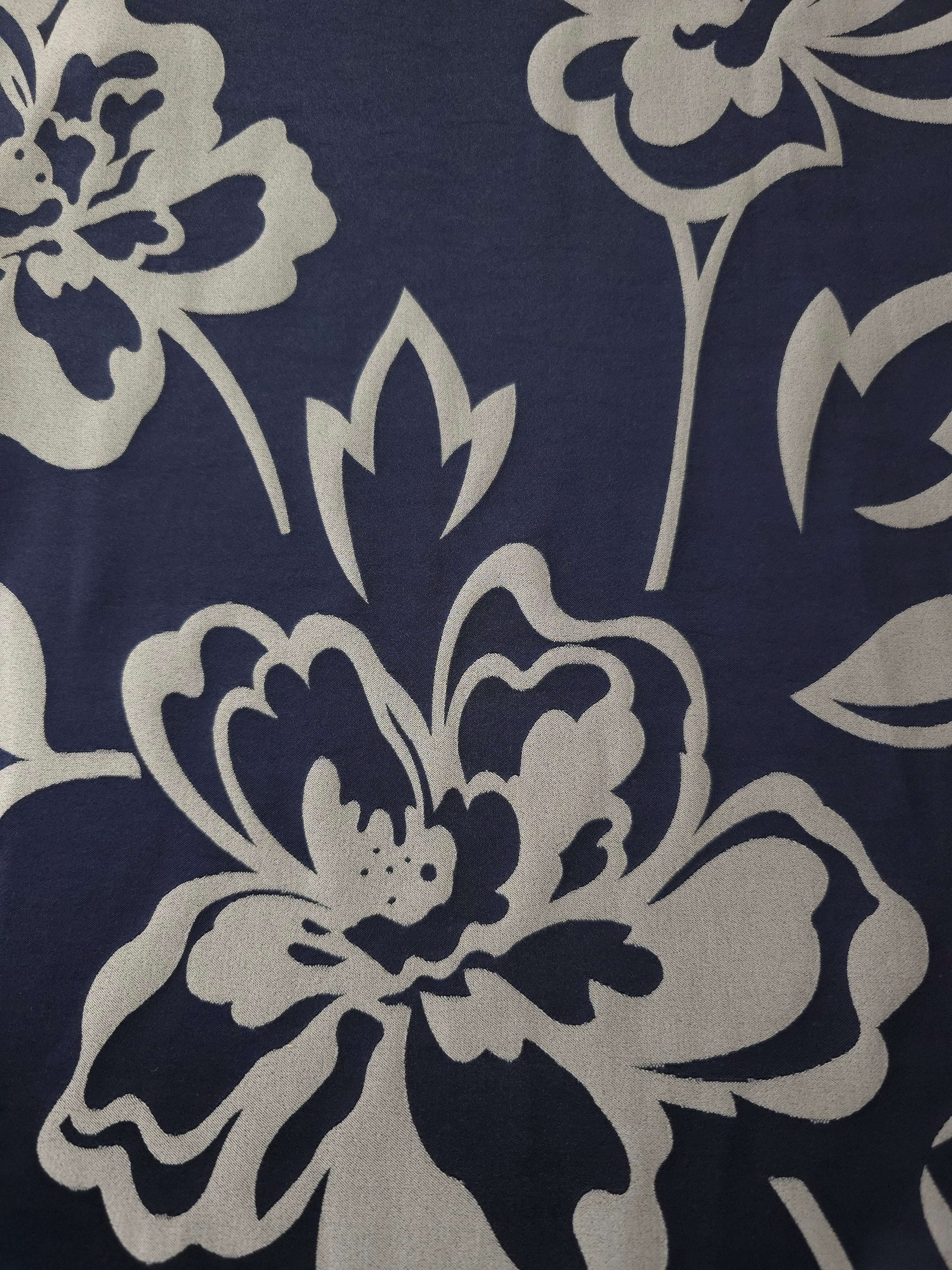 A wider section of the navy and silver pansy flower satin, shown to judge the bold floral pattern at scale