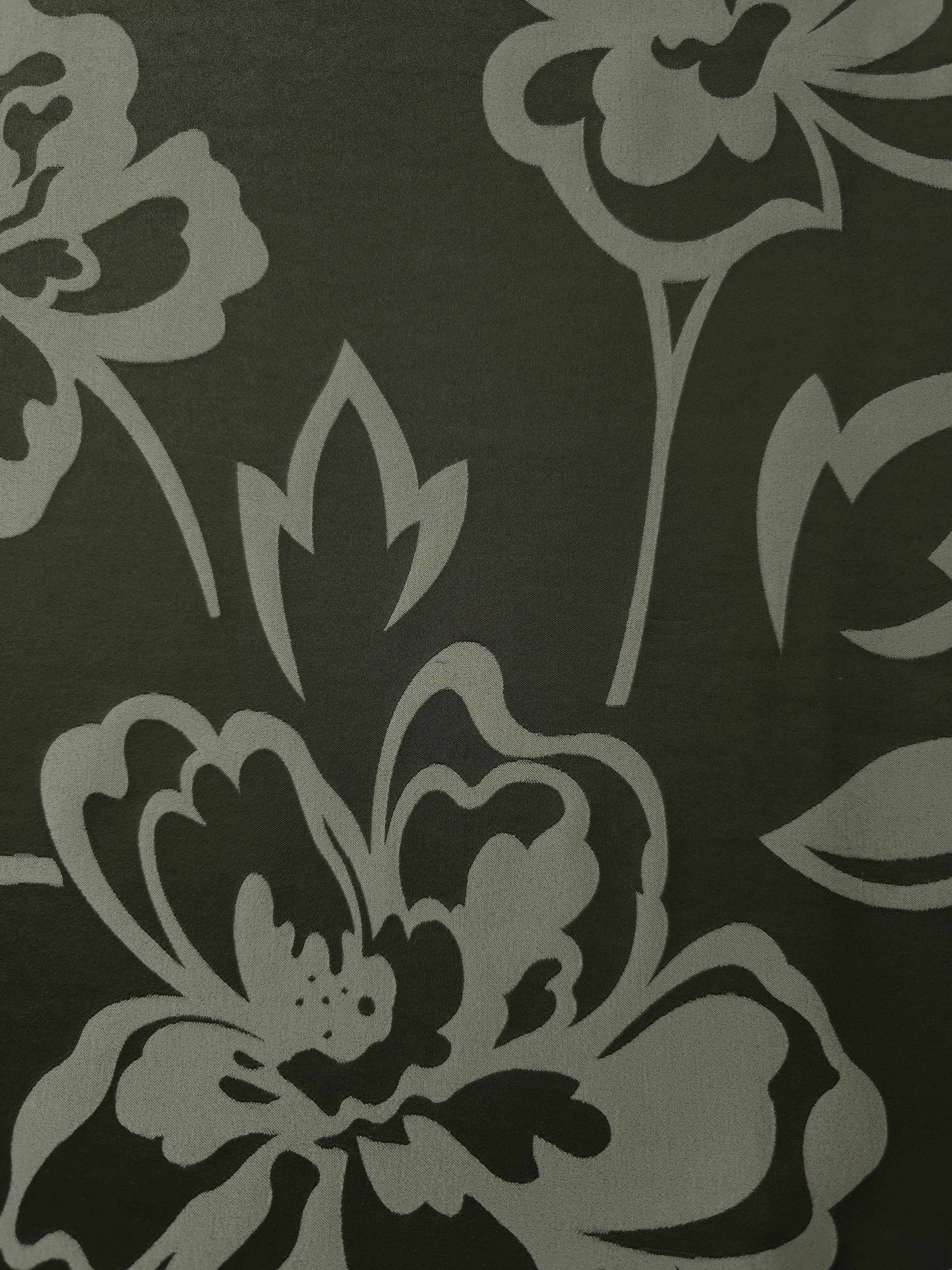 A wider view of the forest green pansy flower satin laid flat, showing the full floral repeat
