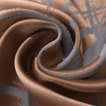 Copper satin pinched into a tight fold, showing how the blue-grey lines hold their shape even where the fabric creases