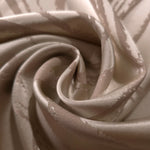 A gentle fold in the champagne satin, showing how understated the seaweed motif reads in this pale tone