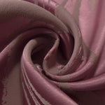 A soft crease in the magenta satin, showing the taupe pattern lines bending with the fabric