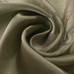 A tight fold in the sage satin, where the mauve lines bend and cross as the fabric creases