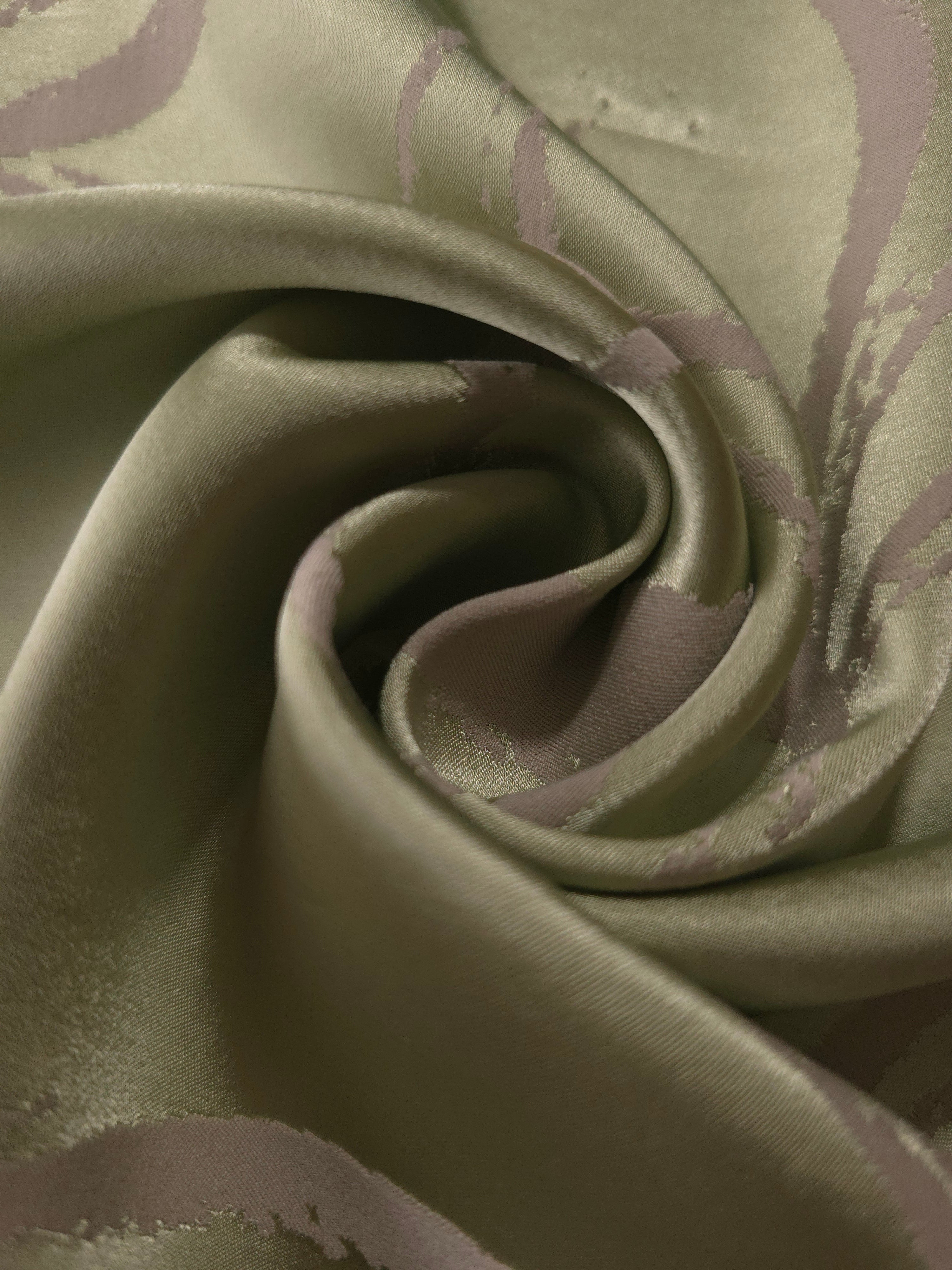 A tight fold in the sage satin, where the mauve lines bend and cross as the fabric creases