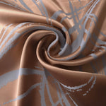 Copper Lassi satin draped loosely, the blue-grey seaweed motif catching light unevenly across the folds