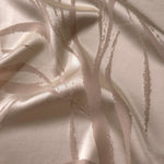 Pale champagne satin folded softly, the seaweed lines barely visible except where the light catches the sheen