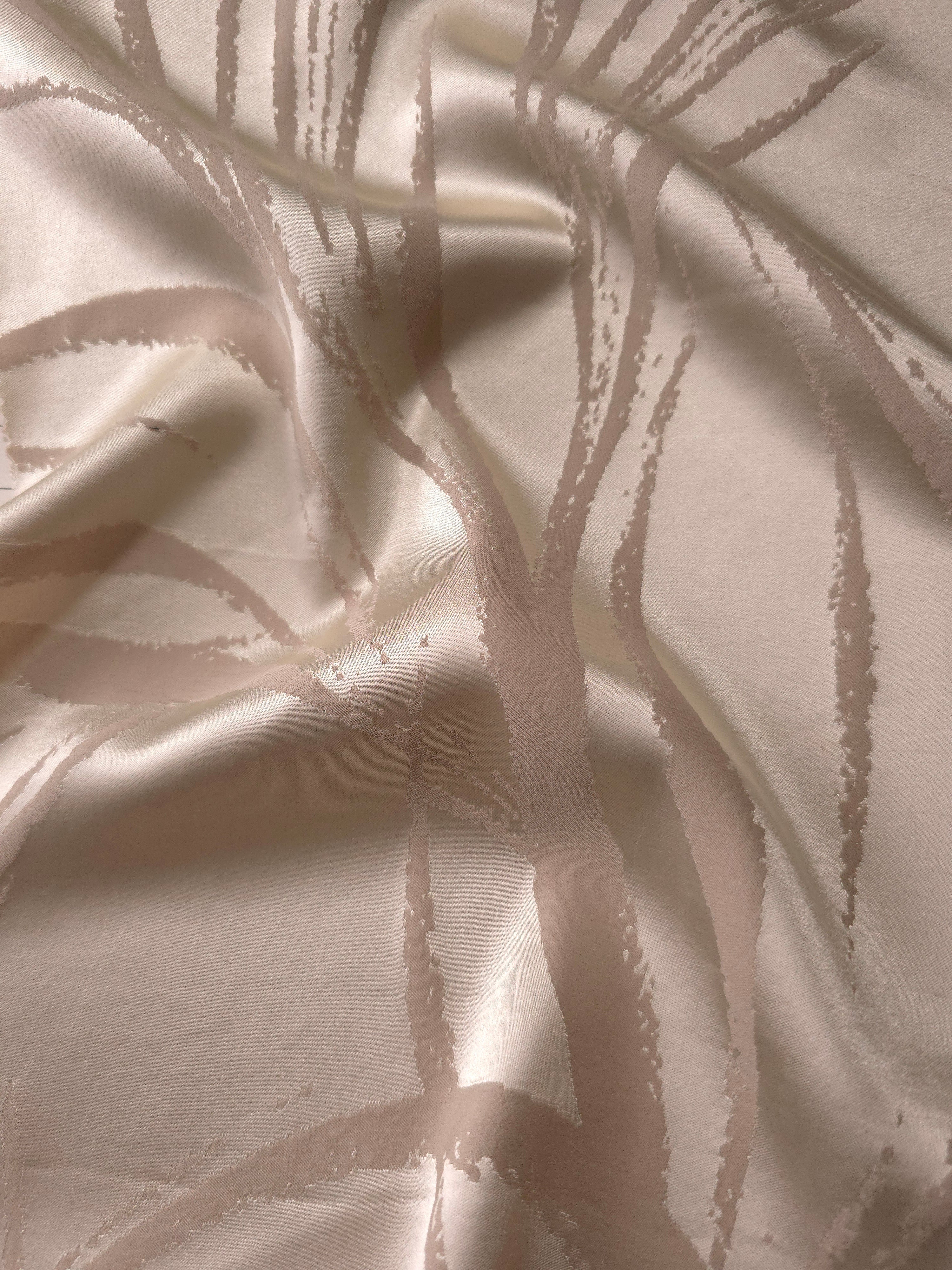 Pale champagne satin folded softly, the seaweed lines barely visible except where the light catches the sheen