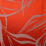 A wider view of the orange-red and ivory seaweed satin, shown to give a sense of the pattern at scale