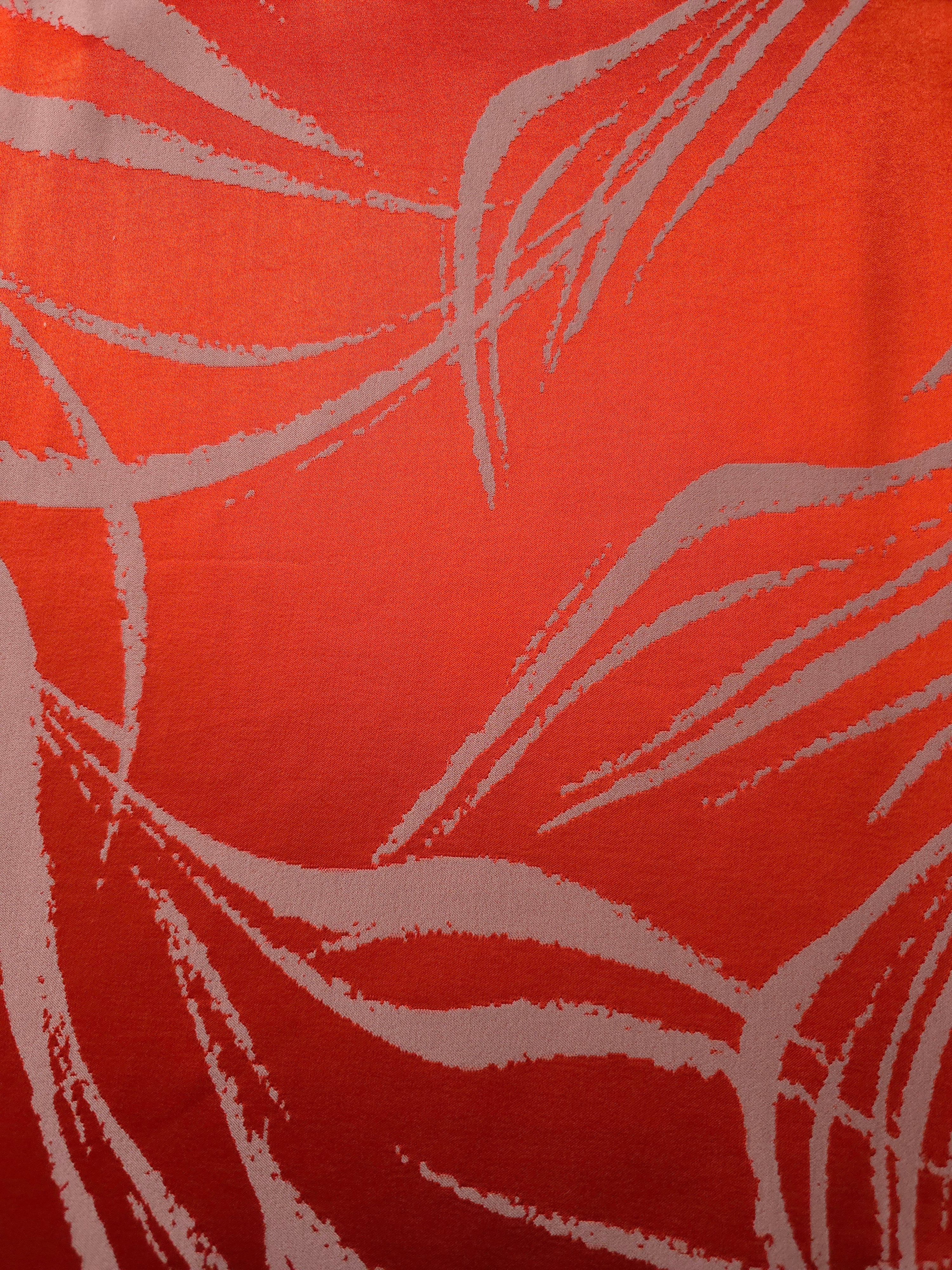 A wider view of the orange-red and ivory seaweed satin, shown to give a sense of the pattern at scale