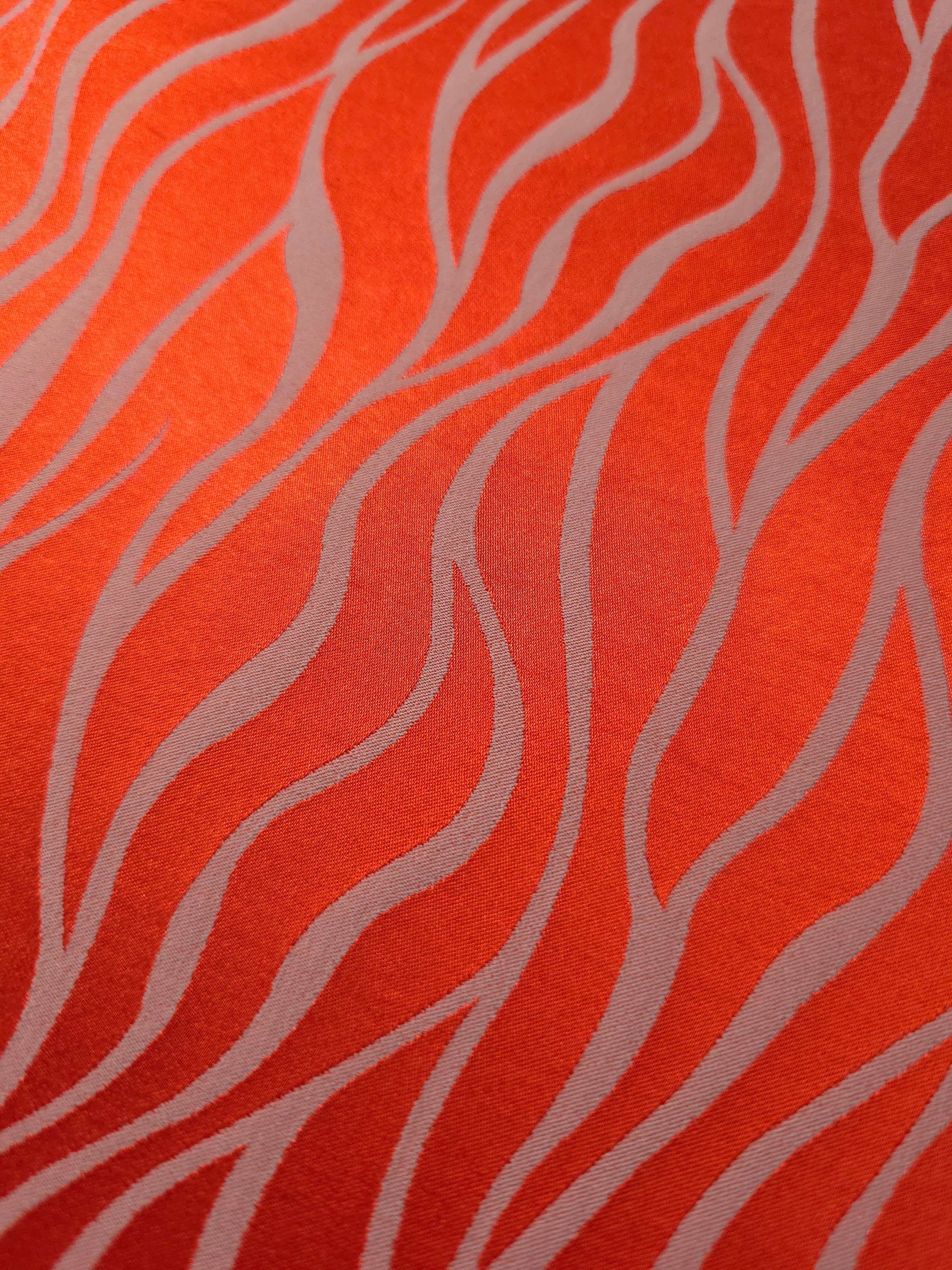 Close-up of the orange-red wave colorway, the highest-contrast option in this fabric's color range