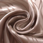 A soft crease in the taupe satin showing how subtly the wave lines separate from the base tone