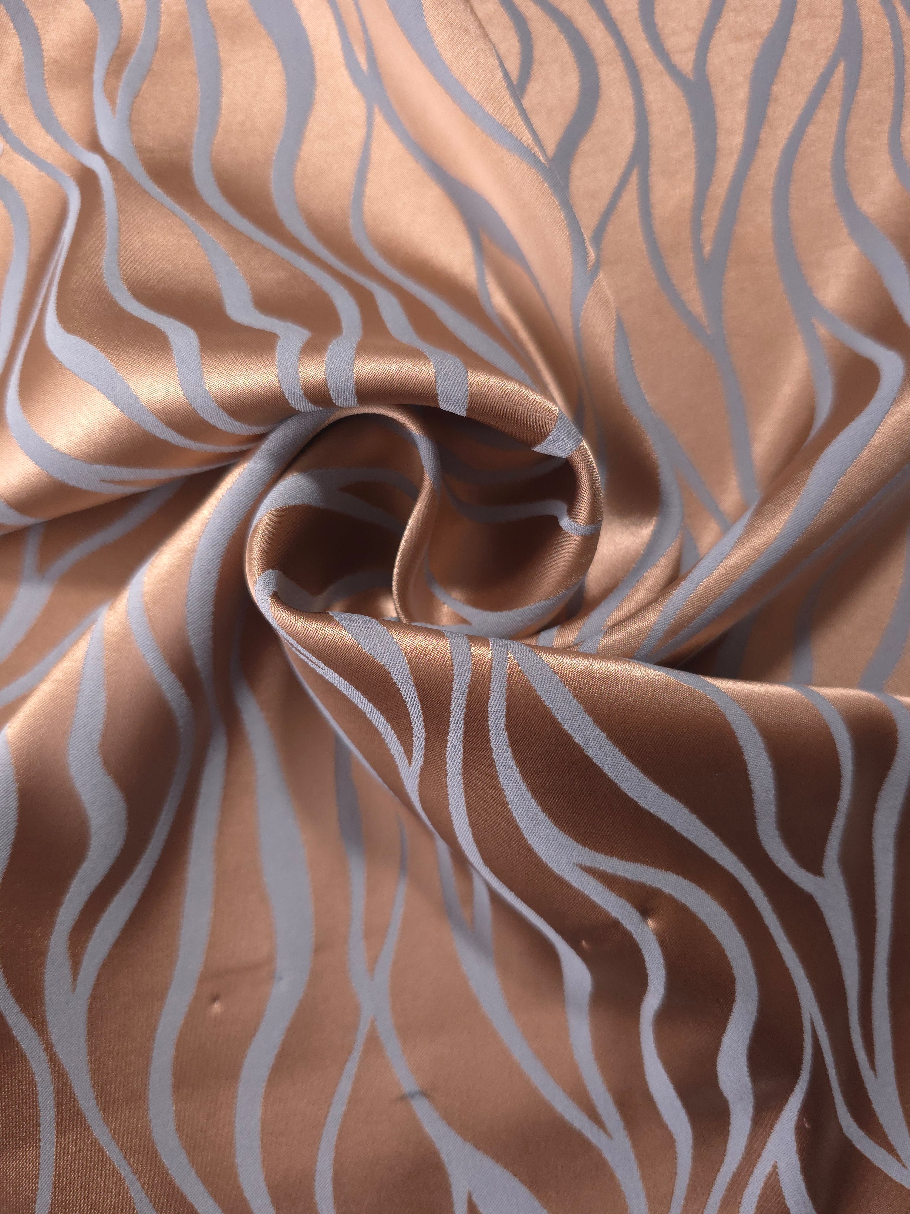 Copper wave-pattern satin draped to show its glossy movement and the contrast of the blue-grey lines