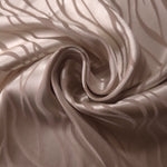 Taupe satin draped in loose waves, the pattern only visible where the fabric catches direct light