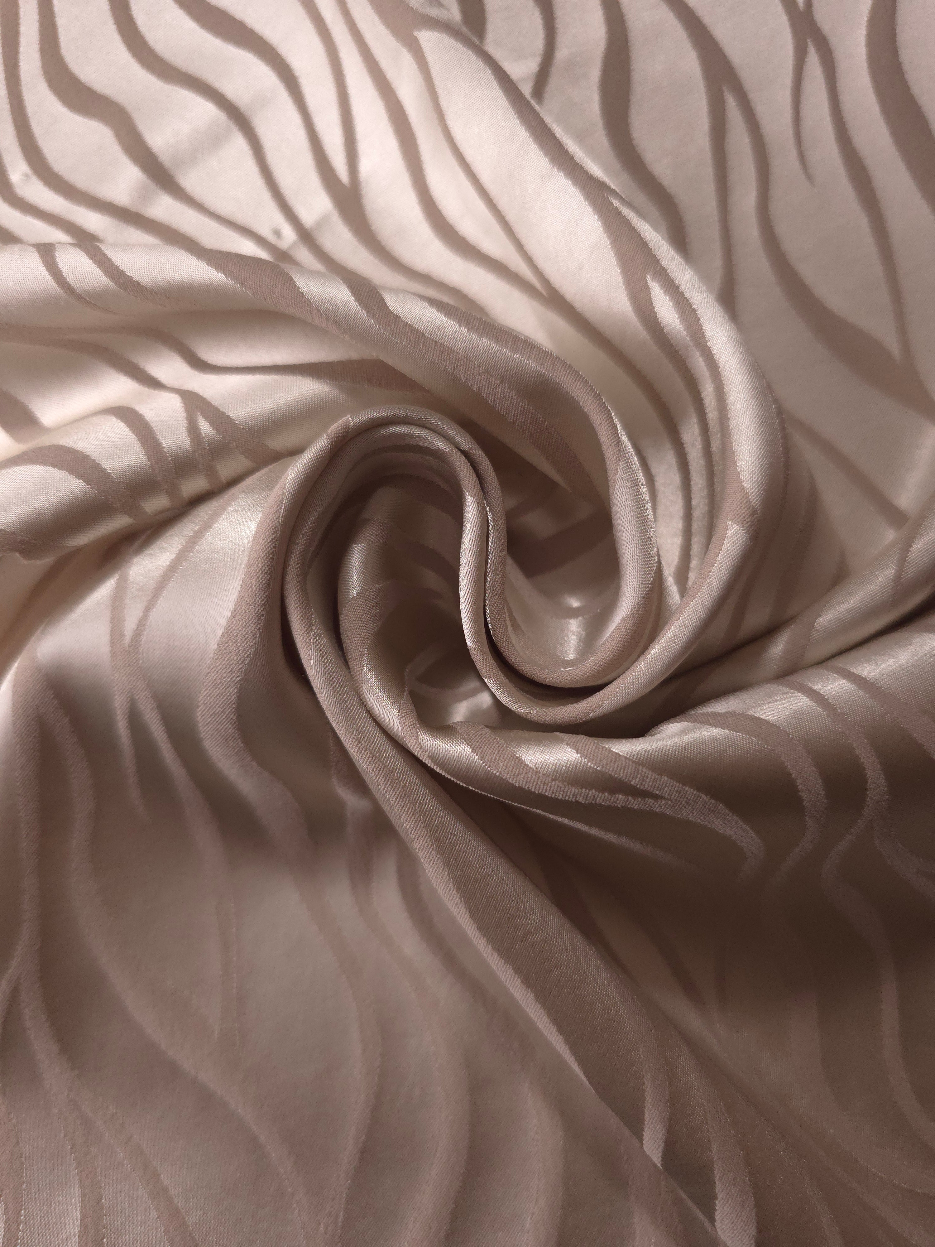 Taupe satin draped in loose waves, the pattern only visible where the fabric catches direct light