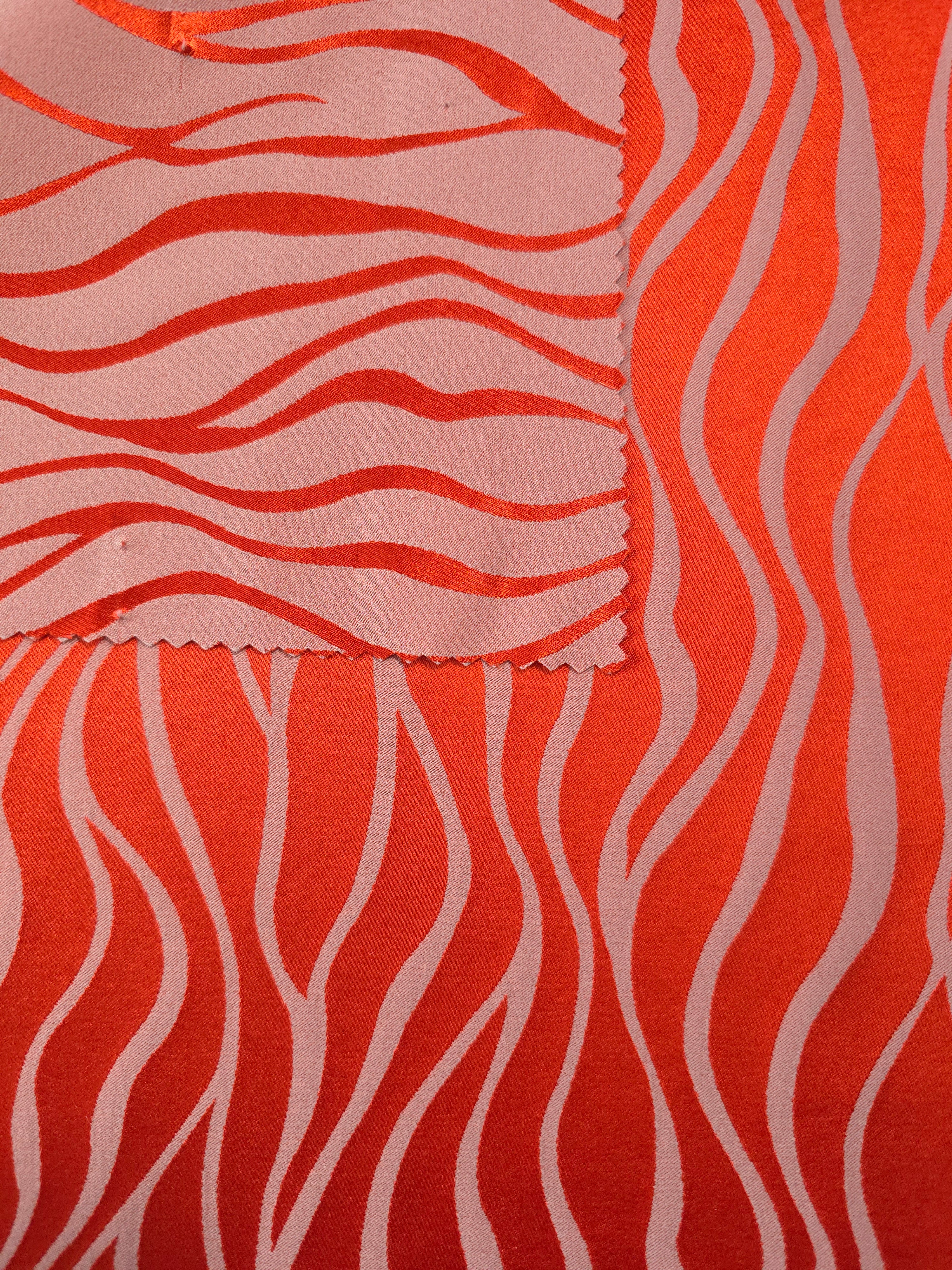 Front and back of the orange-red colorway, the glossy face far more saturated than its muted reverse