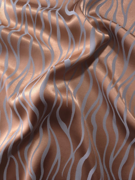Copper Lassi satin folded over itself, the wave lines shifting between warm copper and cool blue-grey as the light moves