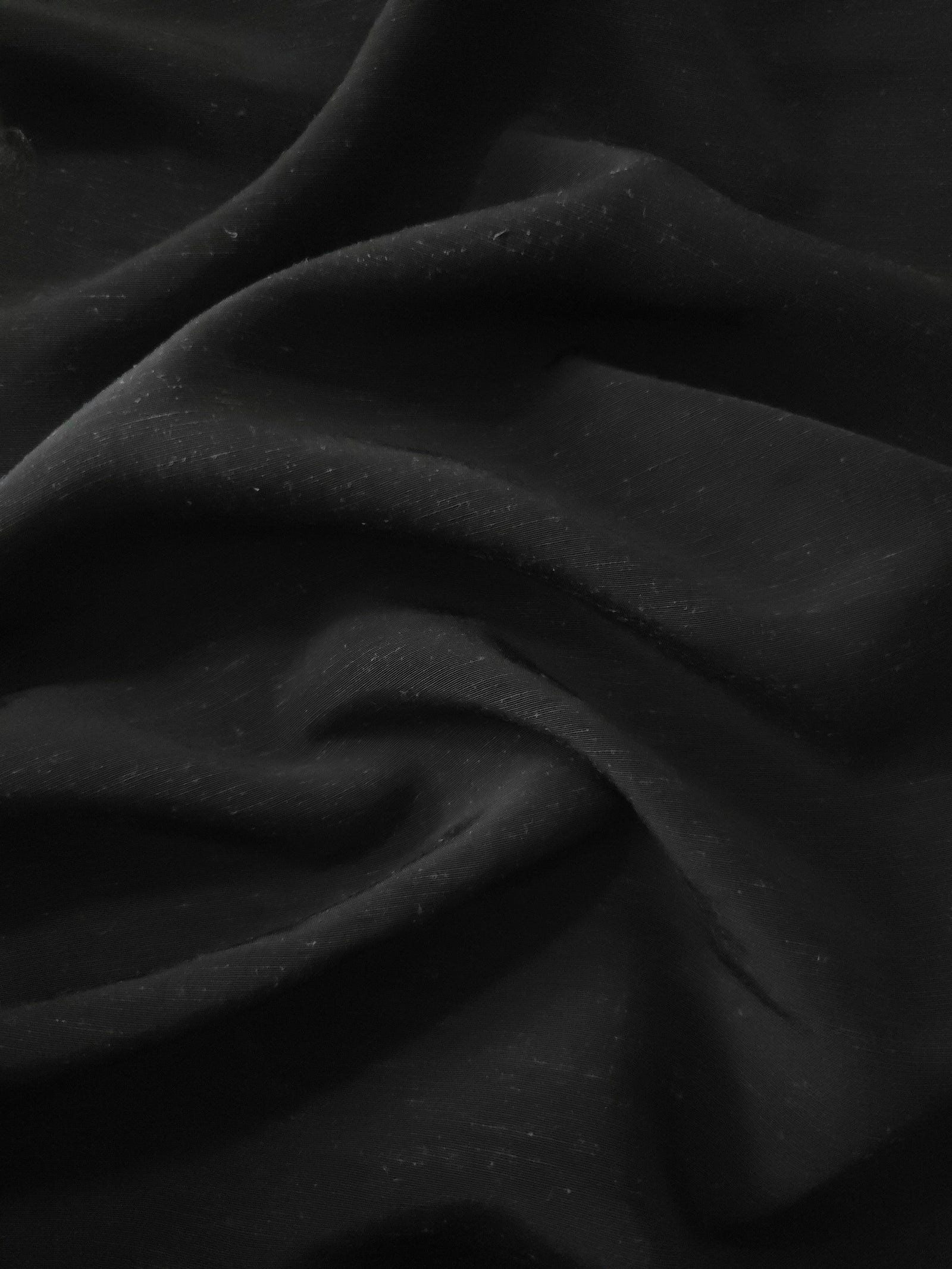 Deep black linen viscose plain fabric styled for modestwear, with a matte, soft-touch finish.