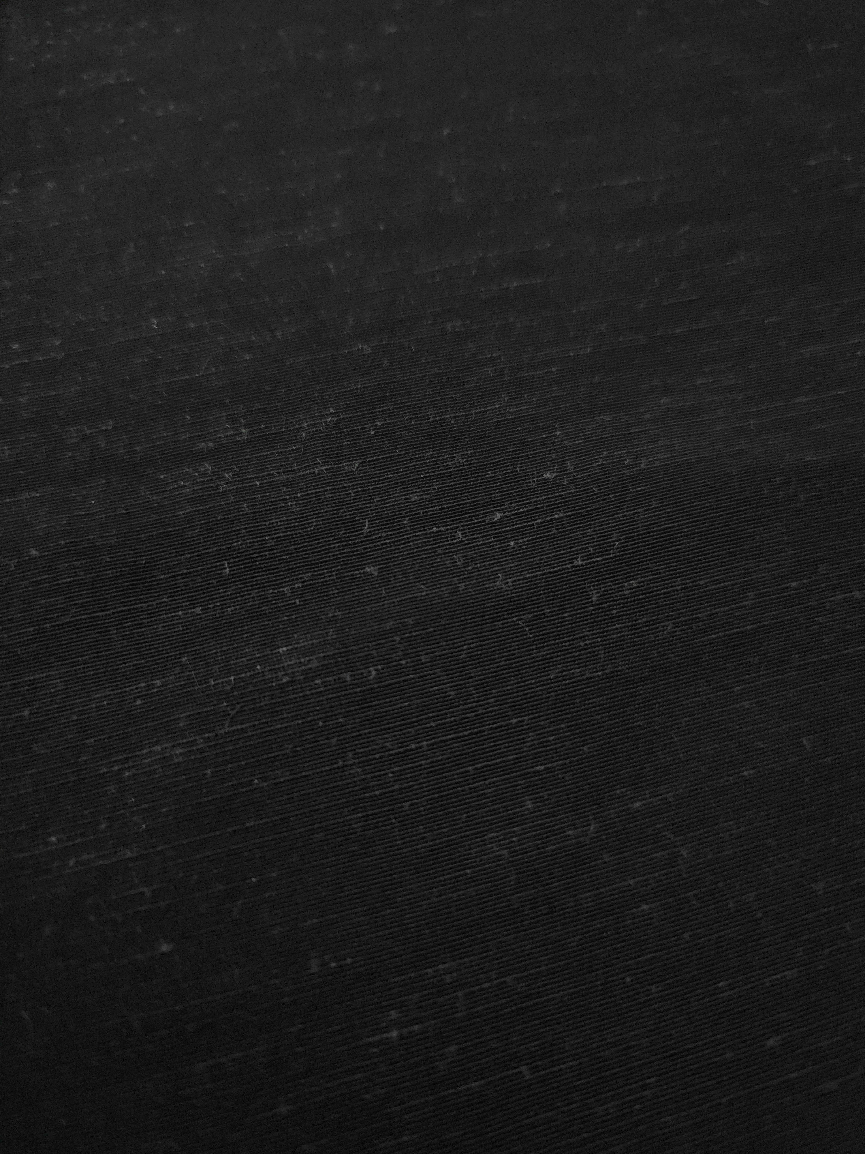 Deep black linen viscose plain fabric draped to show its soft structure, ideal for dressmaking.
