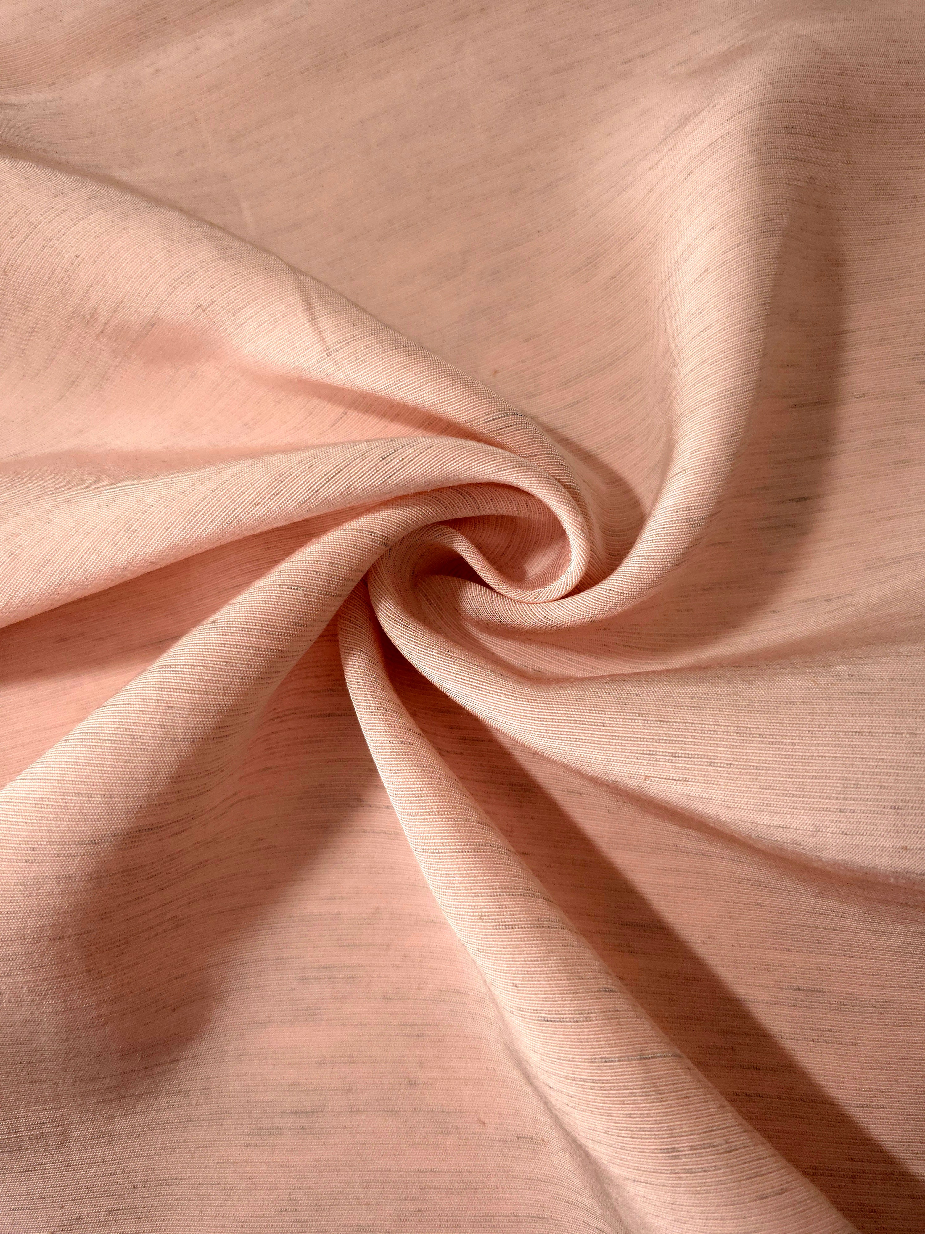 Delicate blush pink linen viscose plain fabric texture, showing the soft, flowy hand of the weave.