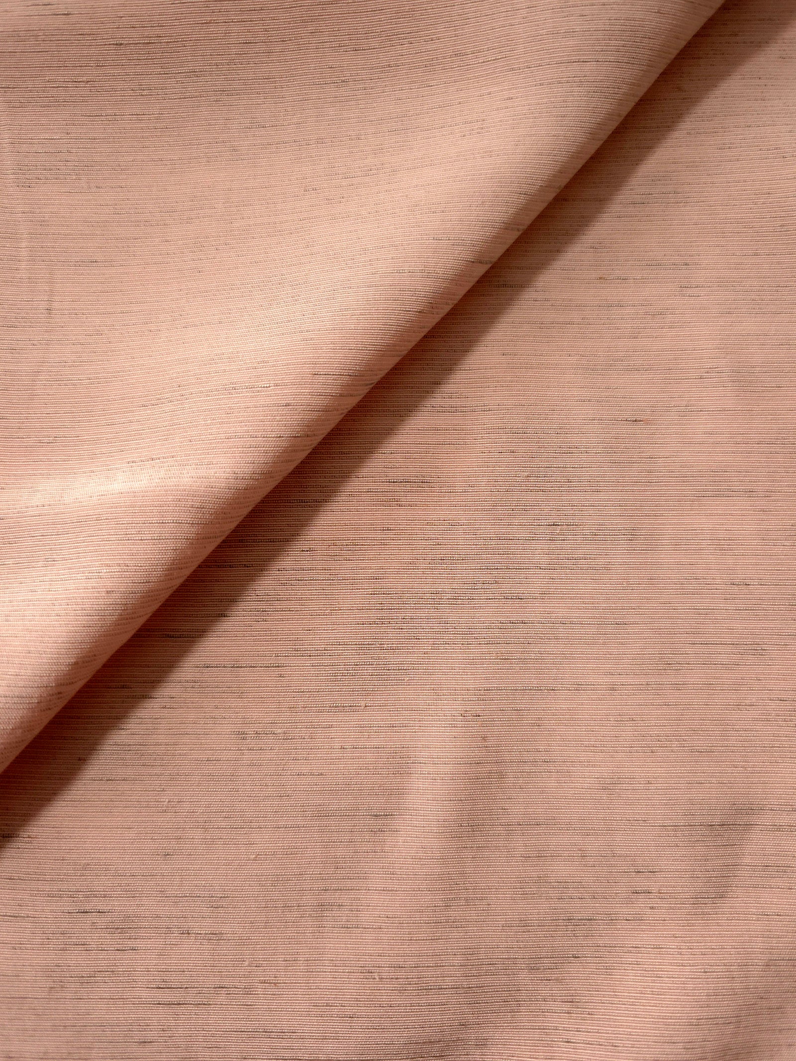 Macro detail of delicate blush pink linen viscose plain fabric, highlighting the plain weave's natural grain.