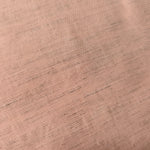 Draped view of delicate blush pink linen viscose plain fabric, showing the fluid drape used for dresses and skirts.