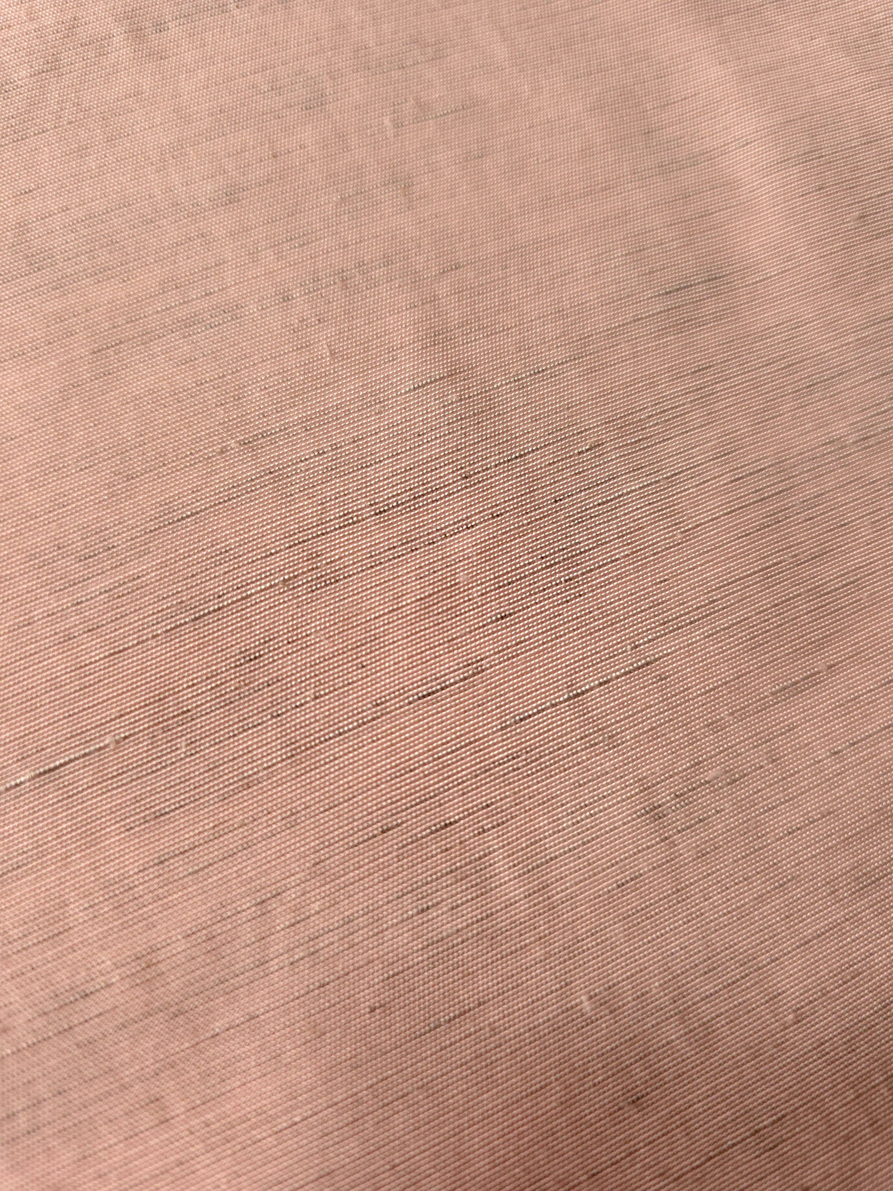 Draped view of delicate blush pink linen viscose plain fabric, showing the fluid drape used for dresses and skirts.