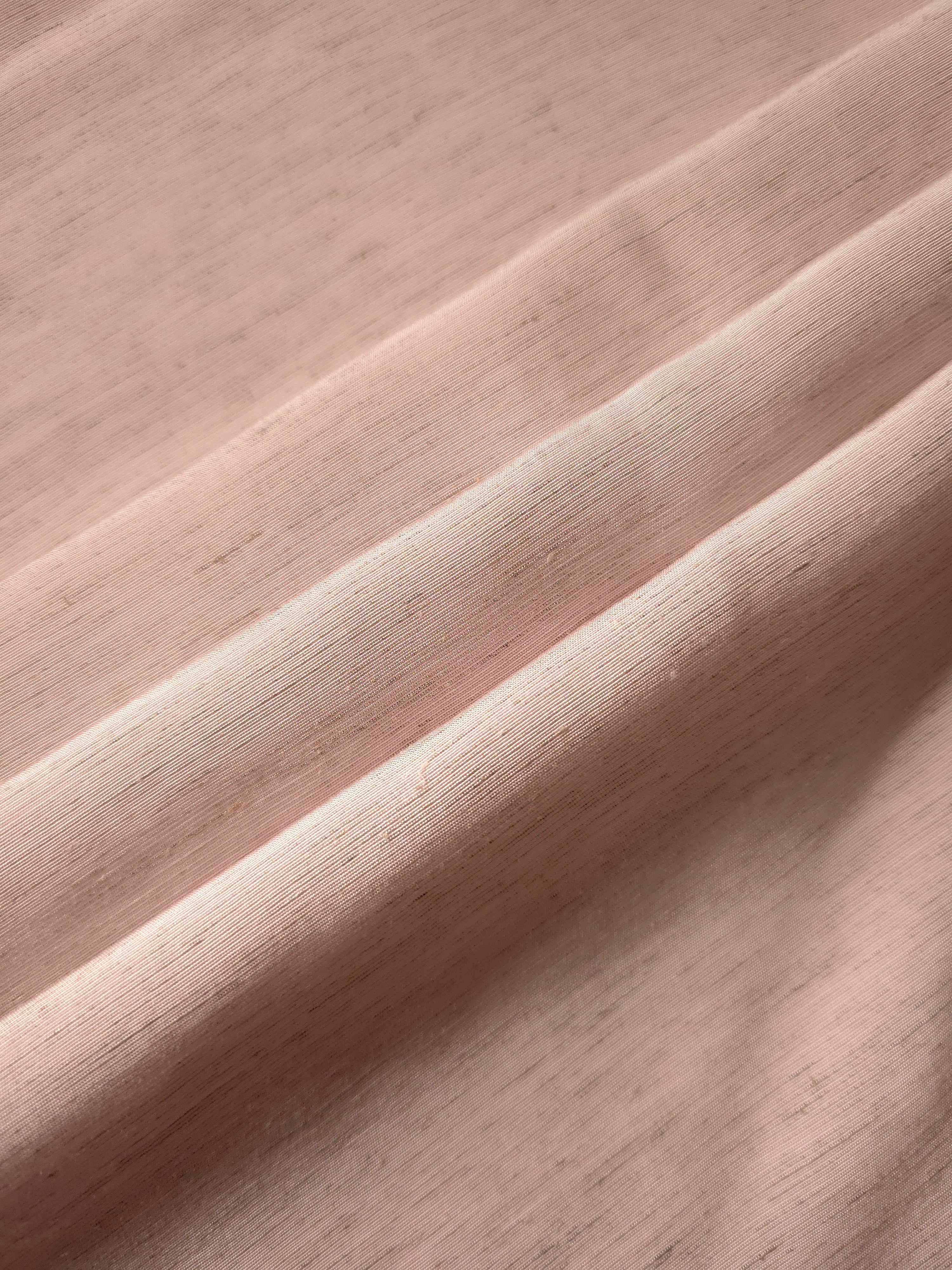 Soft dusty rose linen viscose plain fabric texture, showing the soft, flowy hand of the weave.