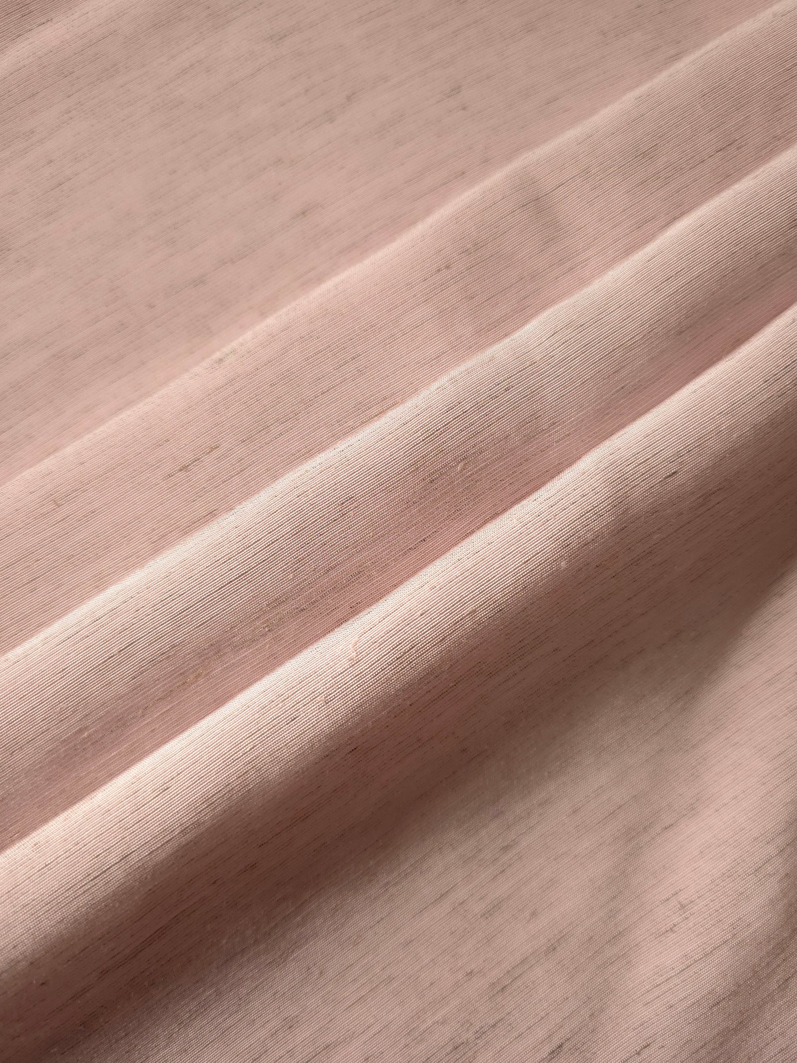 Soft dusty rose linen viscose plain fabric texture, showing the soft, flowy hand of the weave.