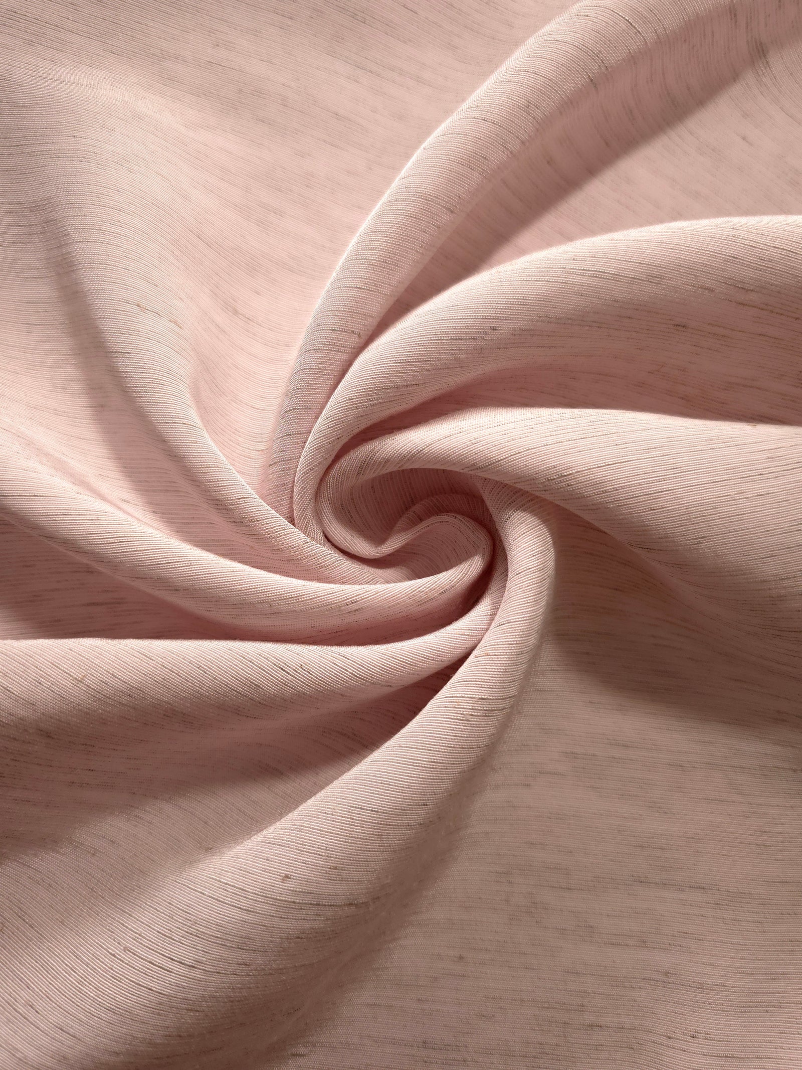 Folded soft dusty rose linen viscose plain fabric, illustrating its lightweight feel for garment sewing.