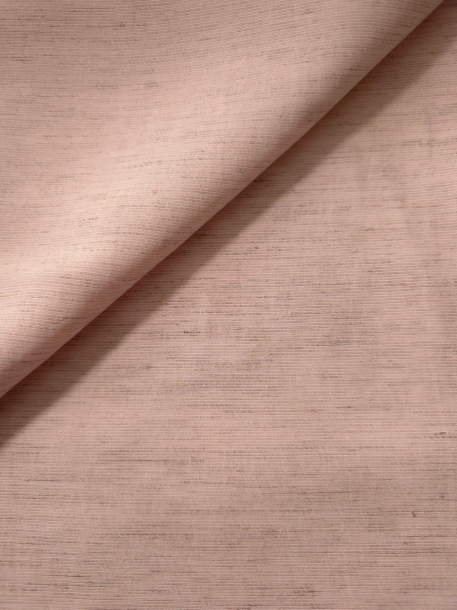 Macro detail of soft dusty rose linen viscose plain fabric, highlighting the plain weave's natural grain.