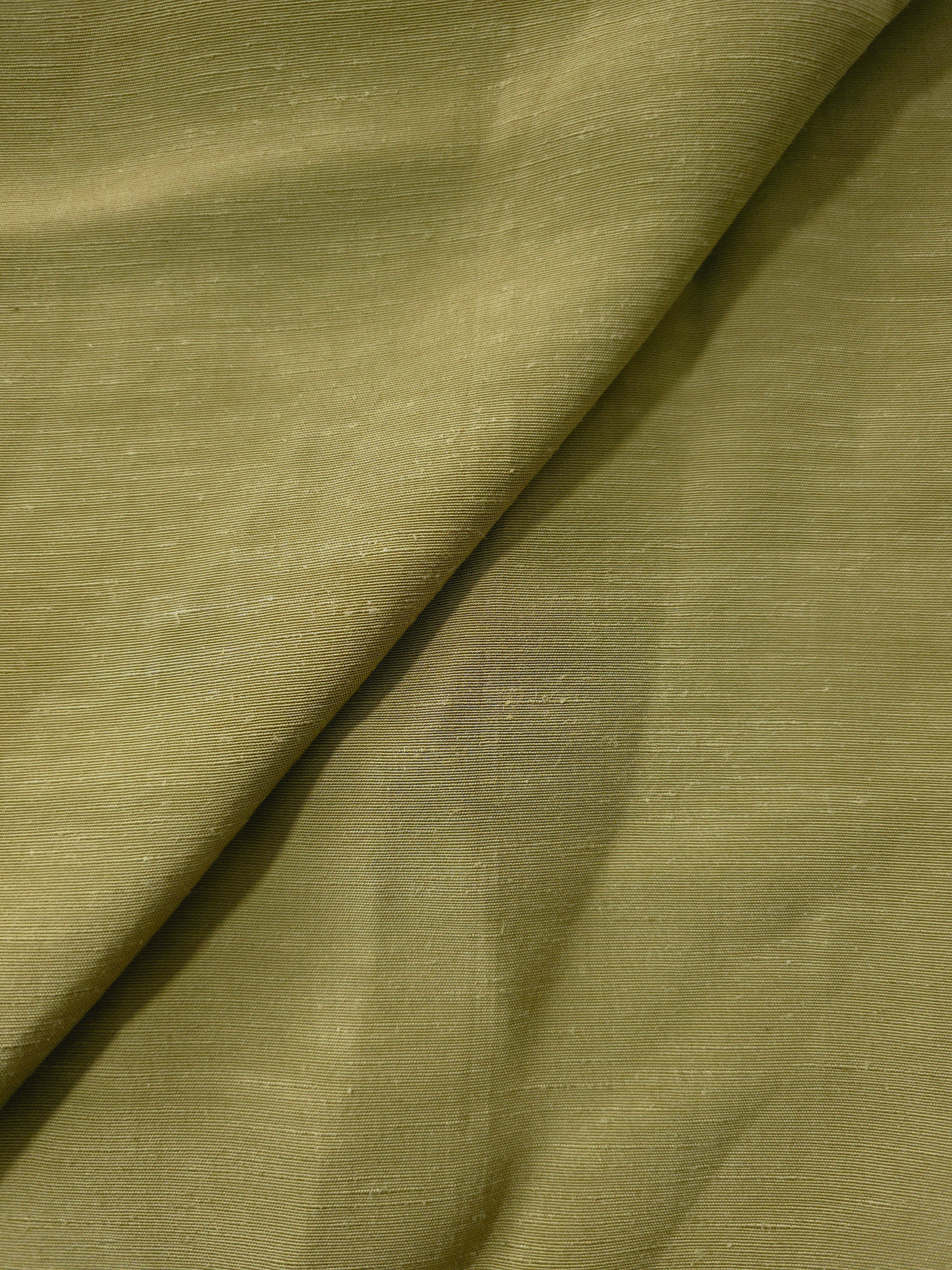 Texture view of fresh apple green linen viscose plain fabric highlighting its flowy, breathable finish.