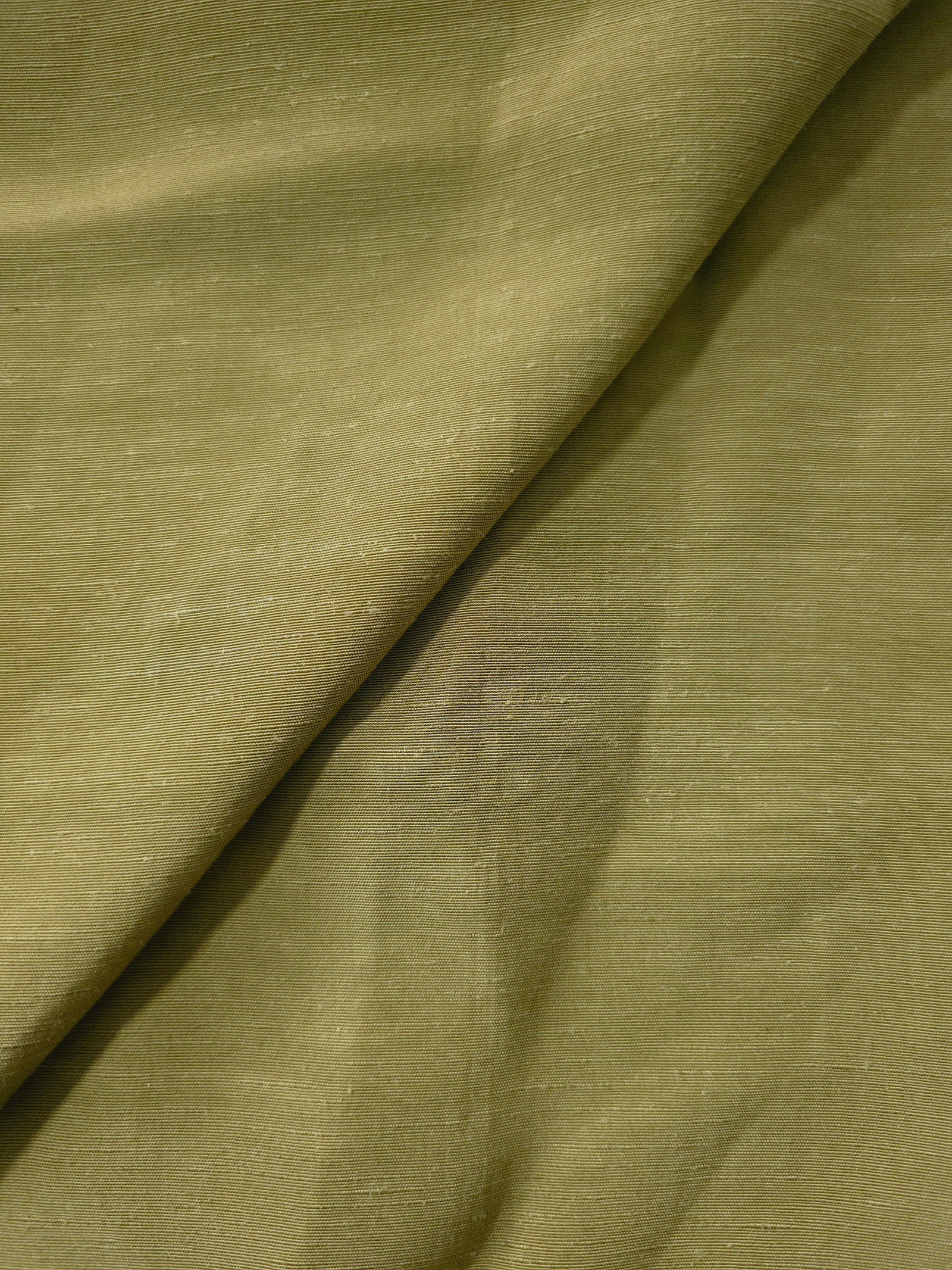 Texture view of fresh apple green linen viscose plain fabric highlighting its flowy, breathable finish.