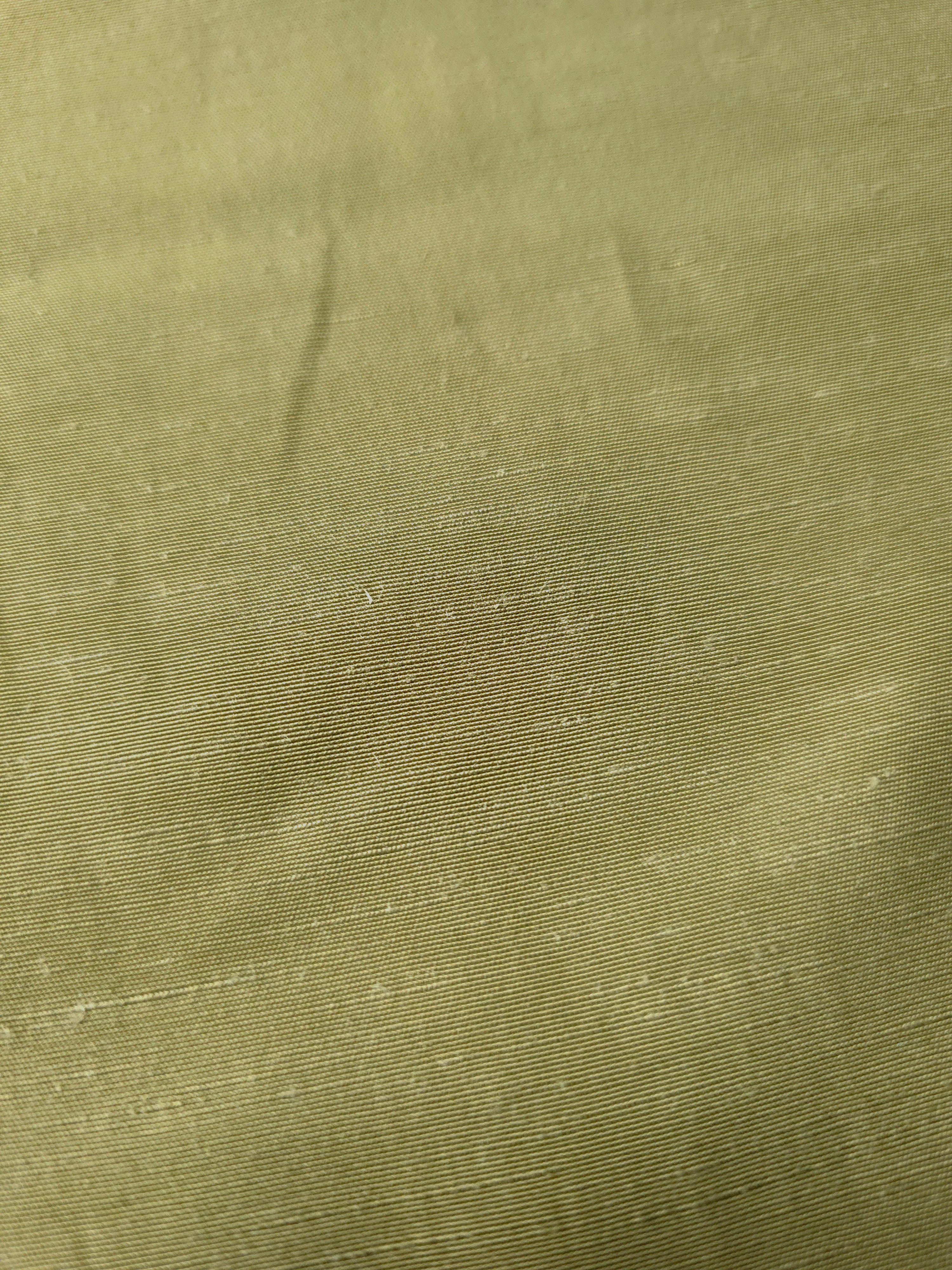 Fresh apple green linen viscose plain fabric draped to show its soft structure, ideal for dressmaking.