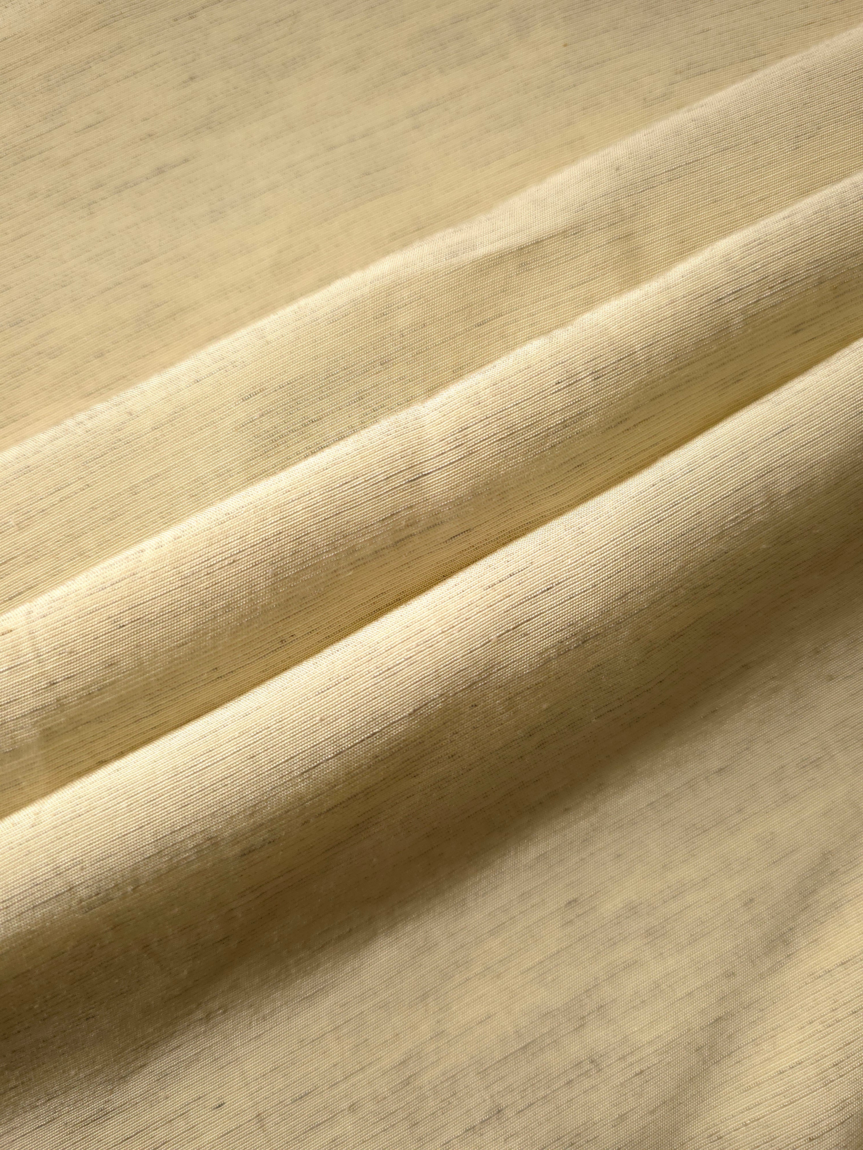 Texture view of soft baby yellow linen viscose plain fabric highlighting its flowy, breathable finish.