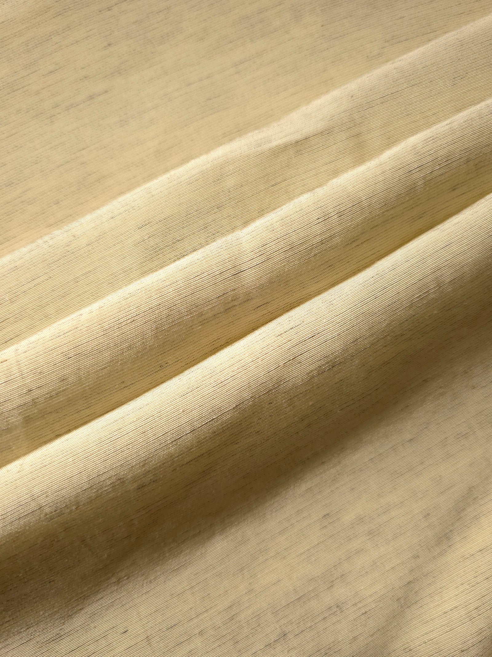 Texture view of soft baby yellow linen viscose plain fabric highlighting its flowy, breathable finish.