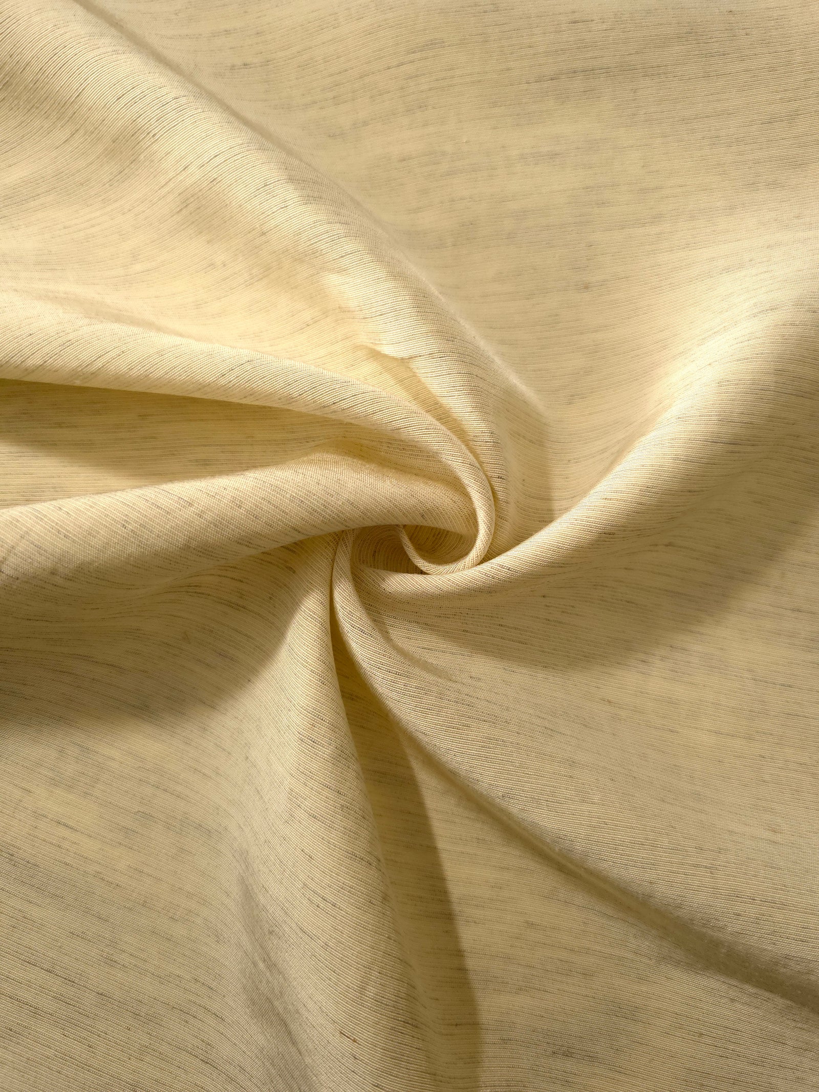 Soft baby yellow linen viscose plain fabric folded to show its lightweight, garment-ready texture.