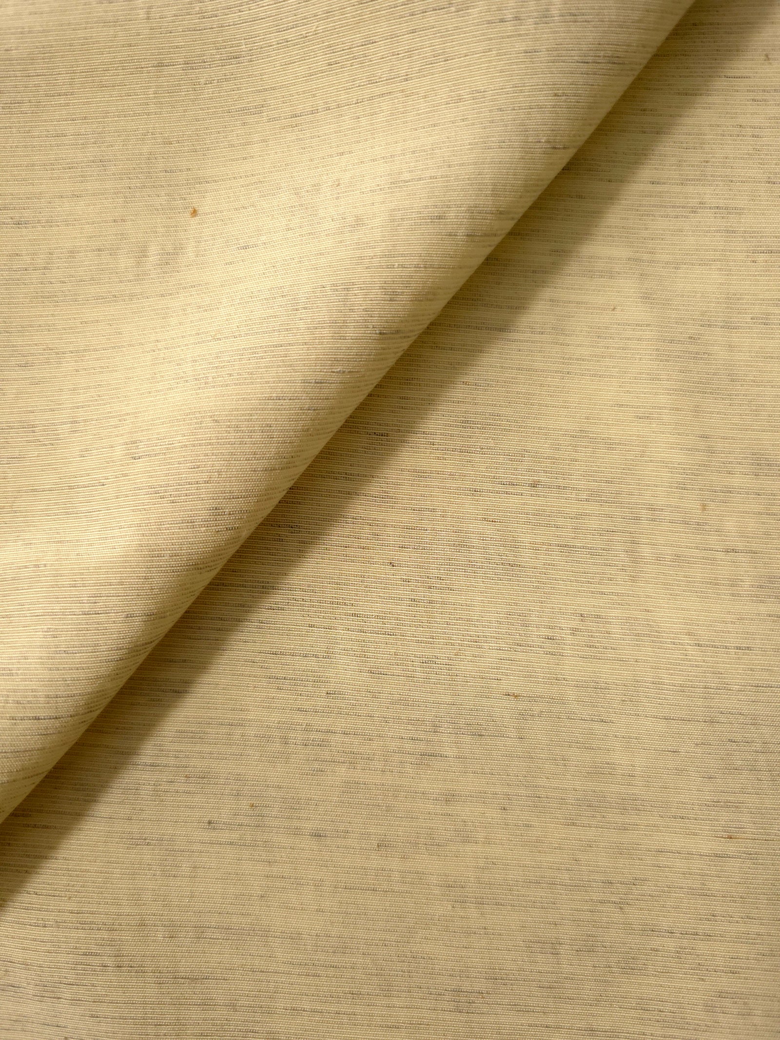 Close-up of soft baby yellow linen viscose plain fabric showing its natural woven texture.