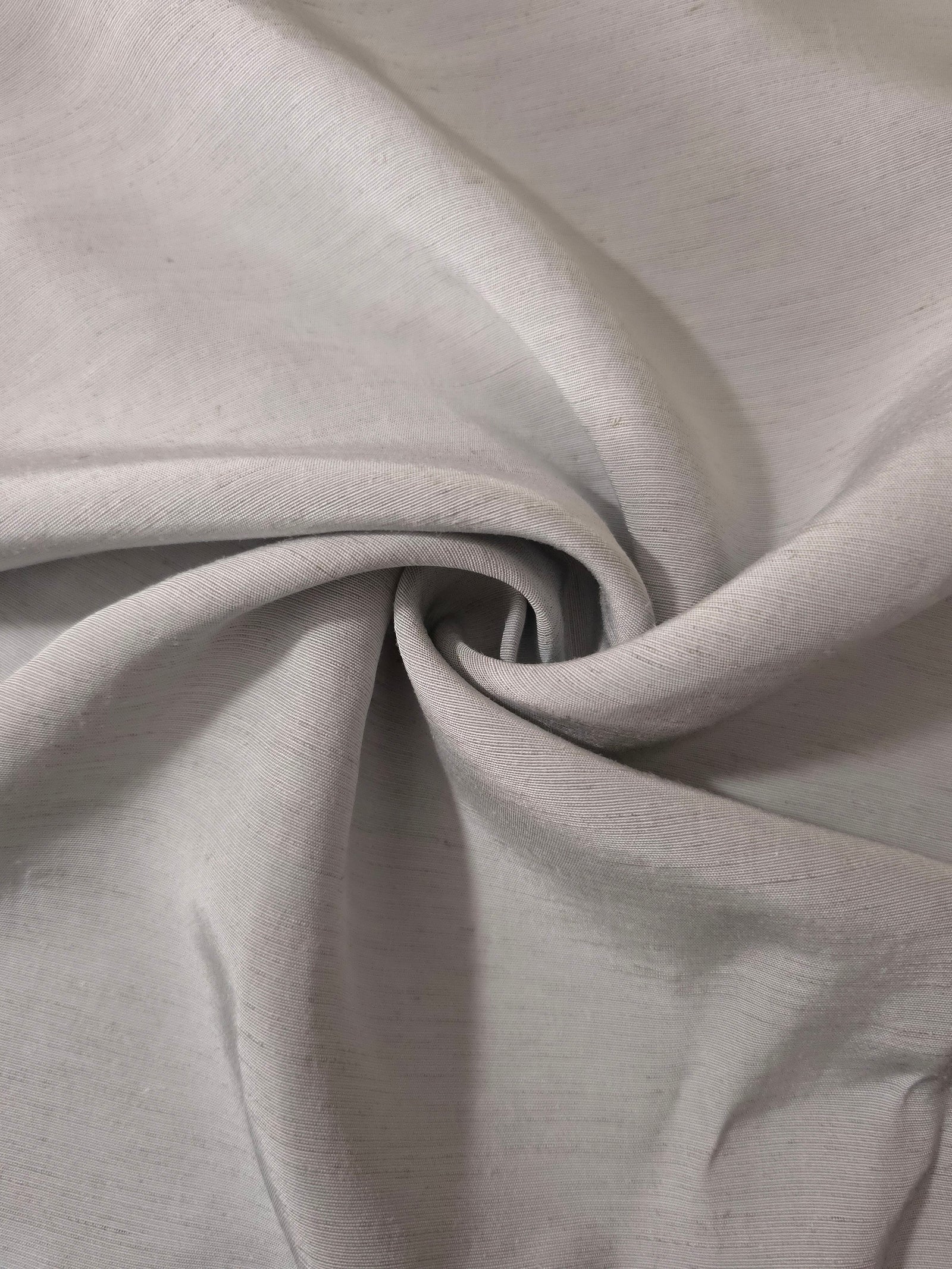 Folded soft pearl grey linen viscose plain fabric, illustrating its lightweight feel for garment sewing.