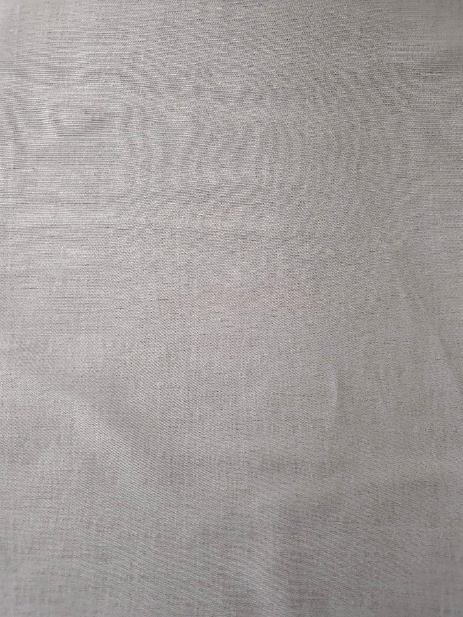 Draped view of soft pearl grey linen viscose plain fabric, showing the fluid drape used for dresses and skirts.
