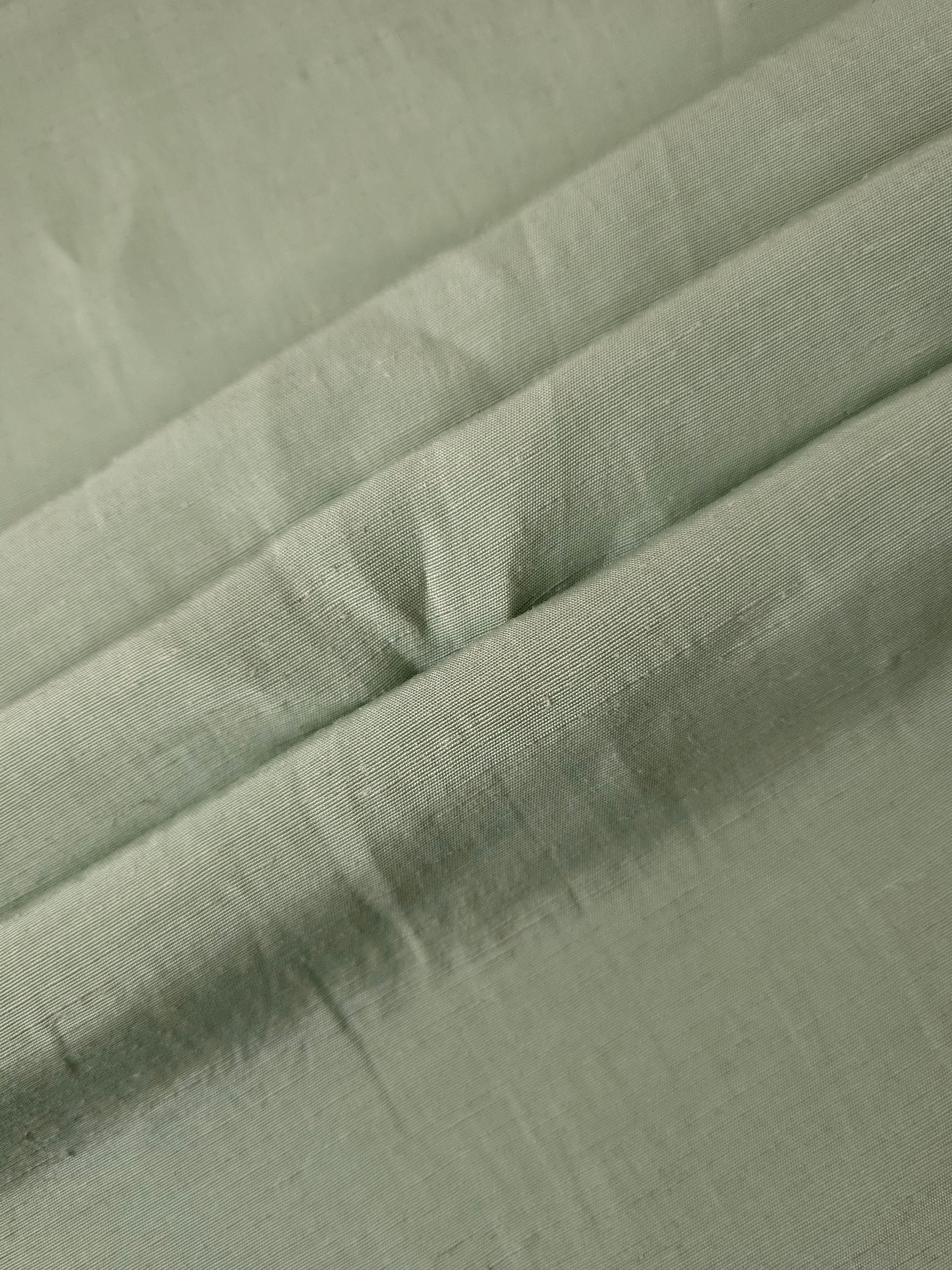 Texture view of muted sage grey linen viscose plain fabric highlighting its flowy, breathable finish.
