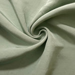 Muted sage grey linen viscose plain fabric folded to show its lightweight, garment-ready texture.