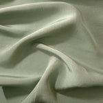 Muted sage grey linen viscose plain fabric styled for modestwear, with a matte, soft-touch finish.