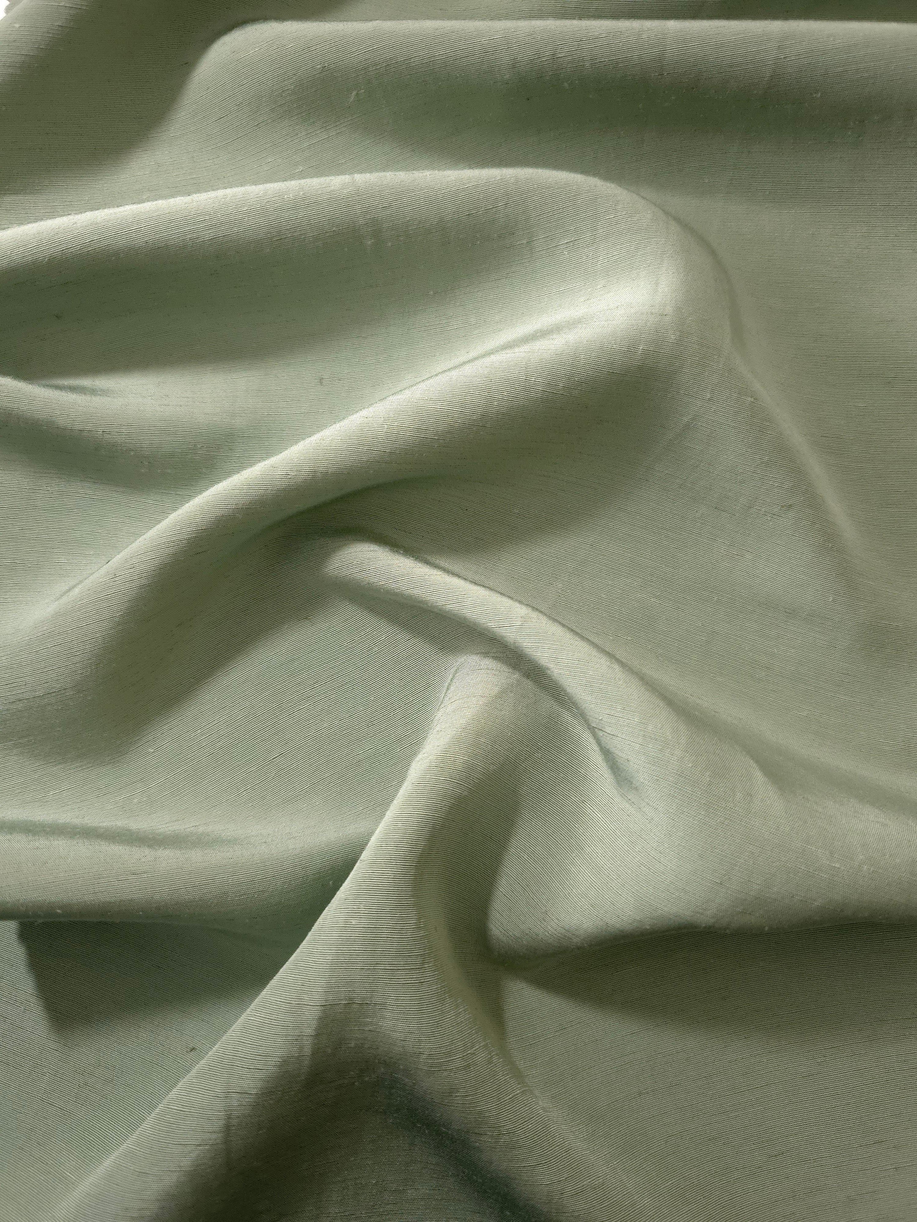 Muted sage grey linen viscose plain fabric styled for modestwear, with a matte, soft-touch finish.
