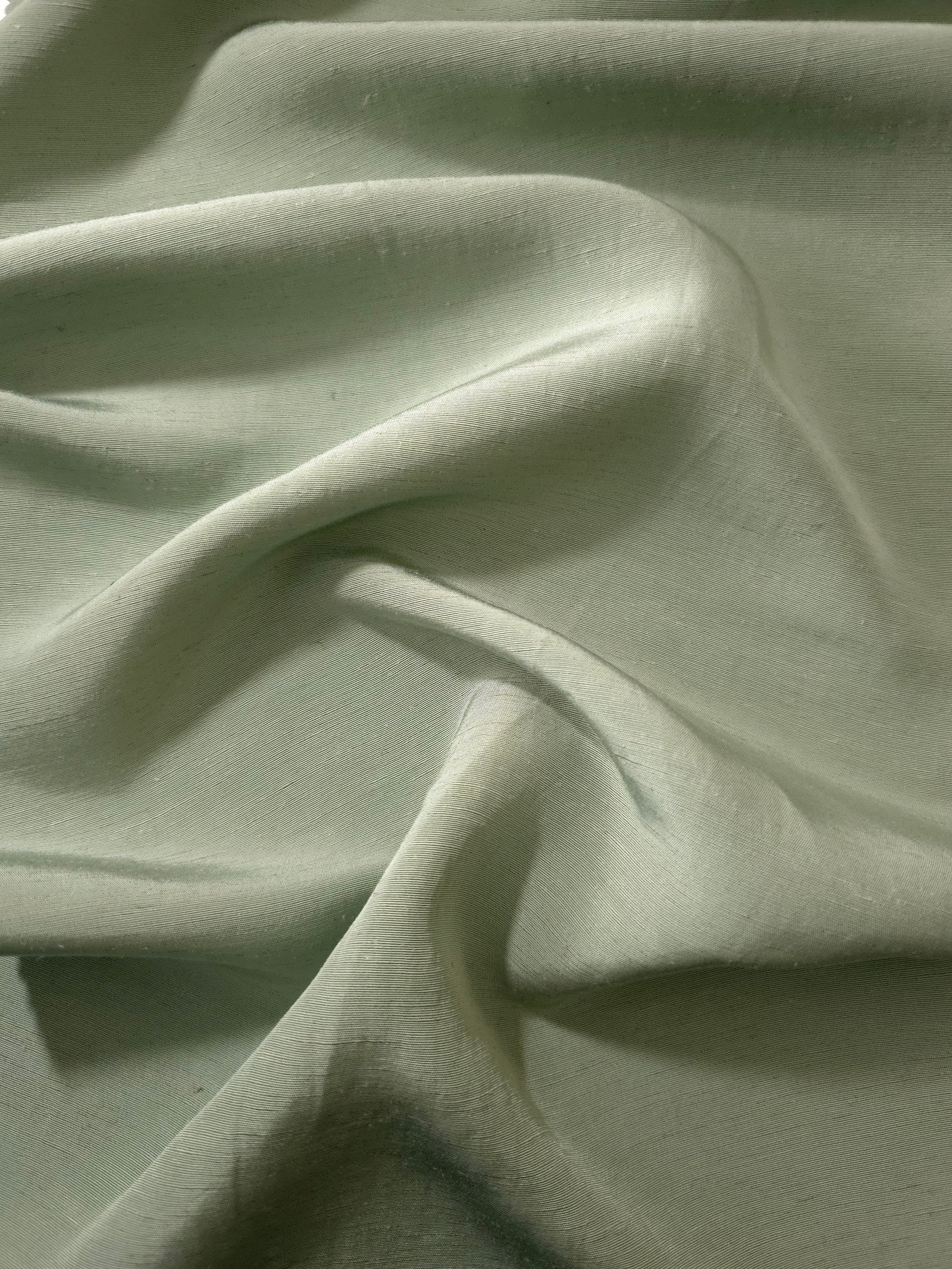 Muted sage grey linen viscose plain fabric styled for modestwear, with a matte, soft-touch finish.