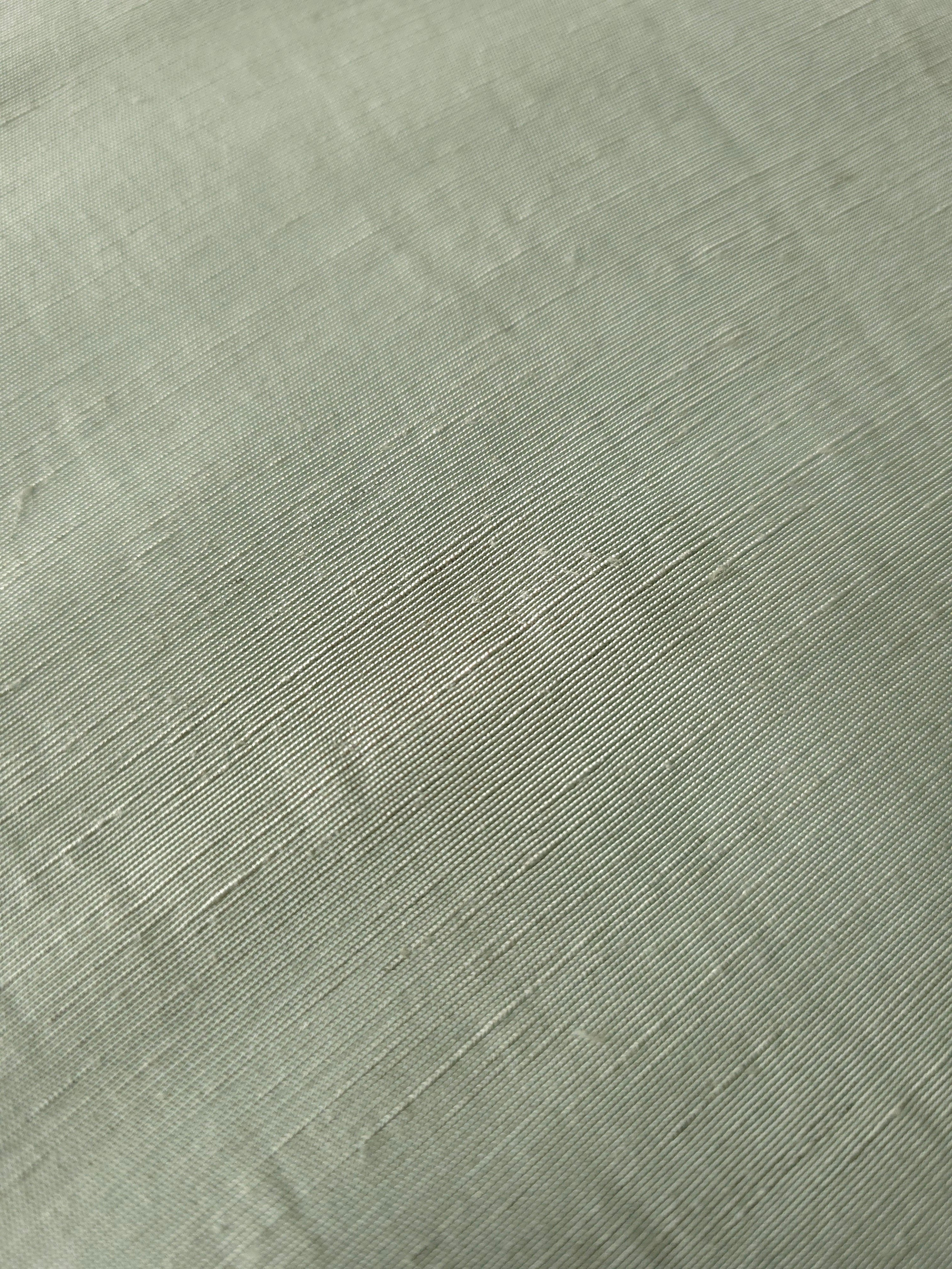Muted sage grey linen viscose plain fabric draped to show its soft structure, ideal for dressmaking.