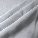 Cool grey-blue linen viscose plain fabric folded to show its lightweight, garment-ready texture.