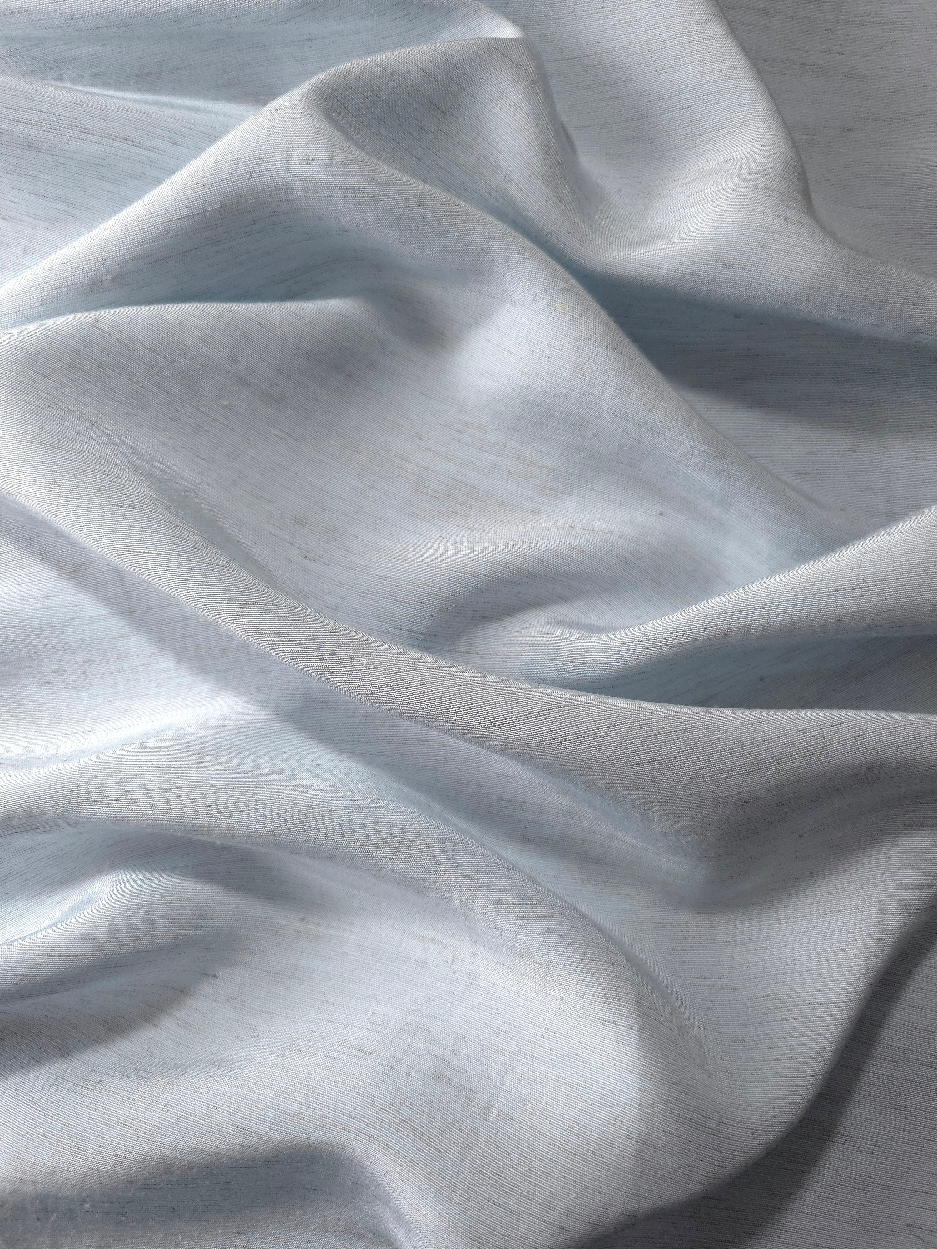 Close-up of cool grey-blue linen viscose plain fabric showing its natural woven texture.