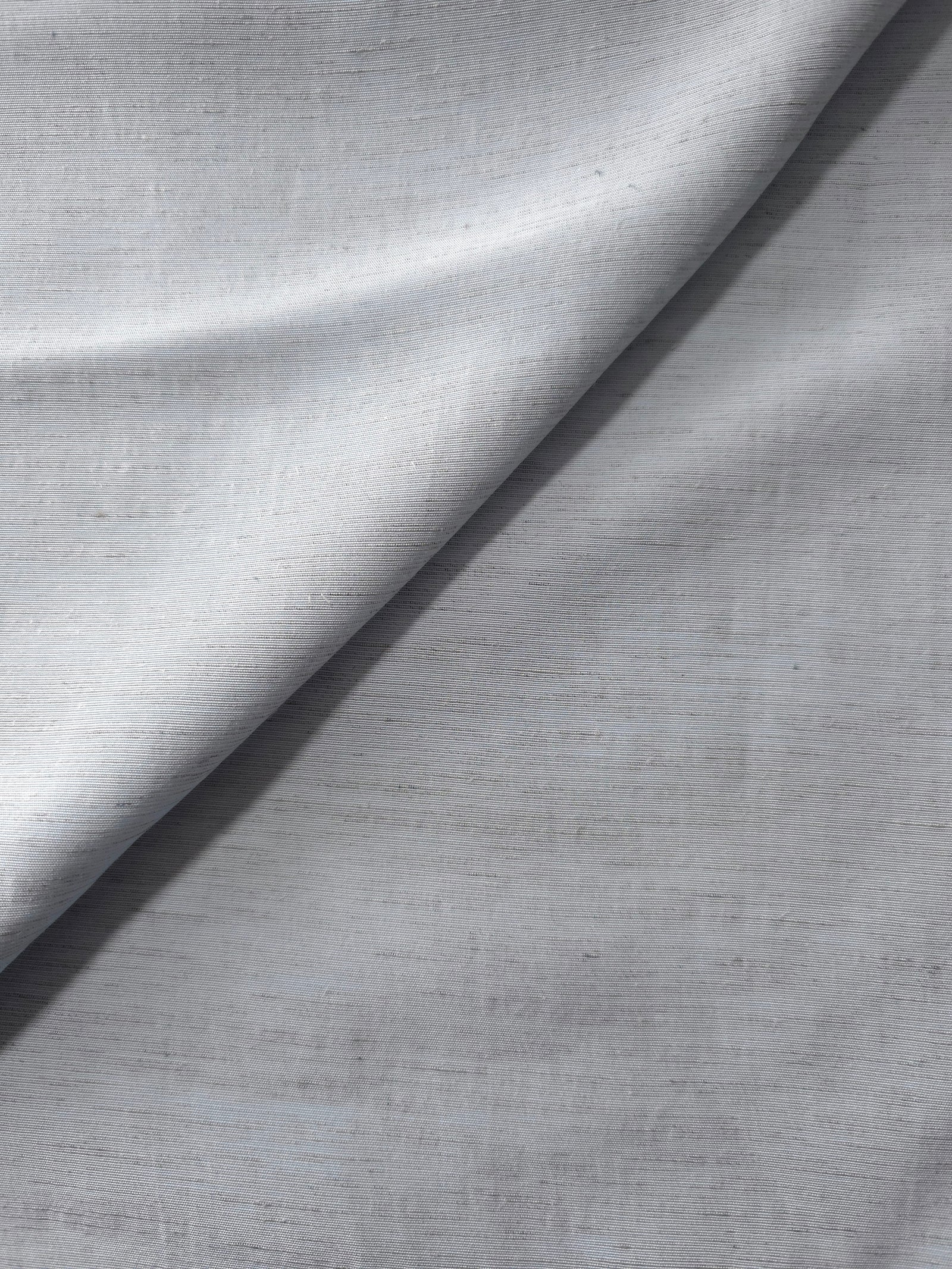 Cool grey-blue linen viscose plain fabric draped to show its soft structure, ideal for dressmaking.